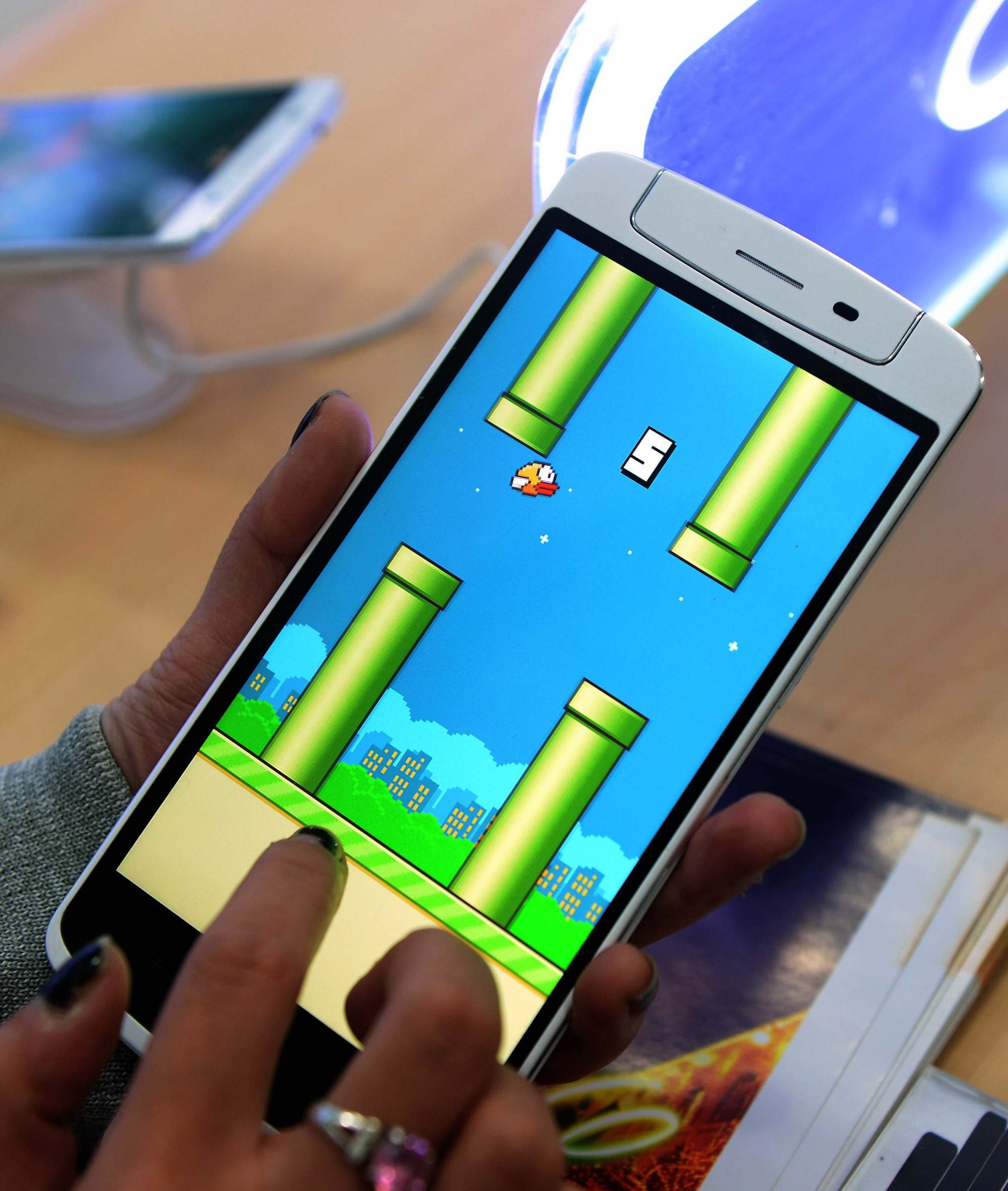 An employee plays the game Flappy Bird at a smartphone store in Hanoi on February 10, 2014. Photo: AFP