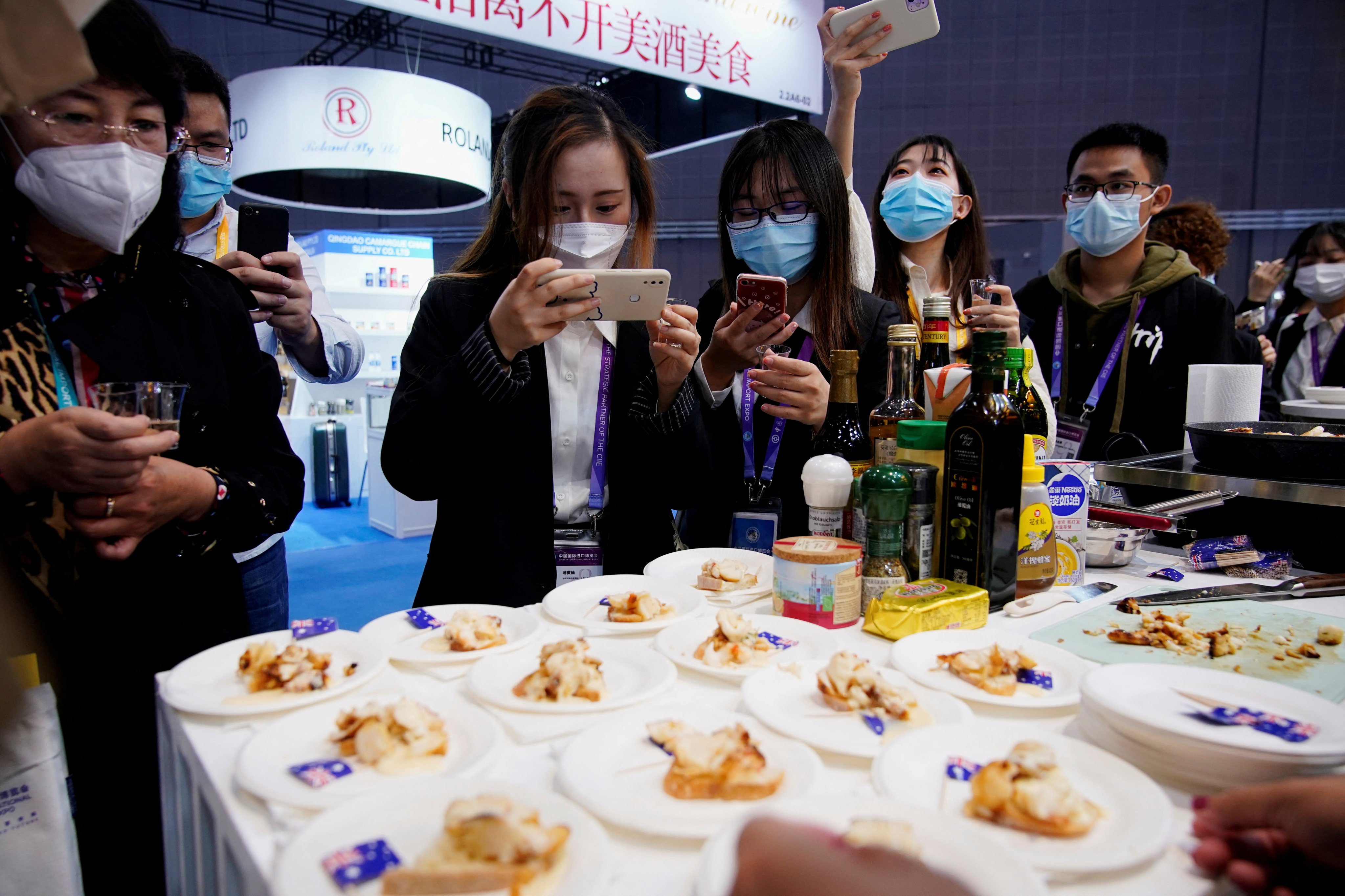People take pictures of Australian lobster at an Australia food booth during the third China International Import Expo in Shanghai on November 6, 2020. The return of face-to-face diplomatic visits and Australian coal reaching Chinese ports has raised hopes of a continued thaw in ties between Australia and China. Photo: Reuters