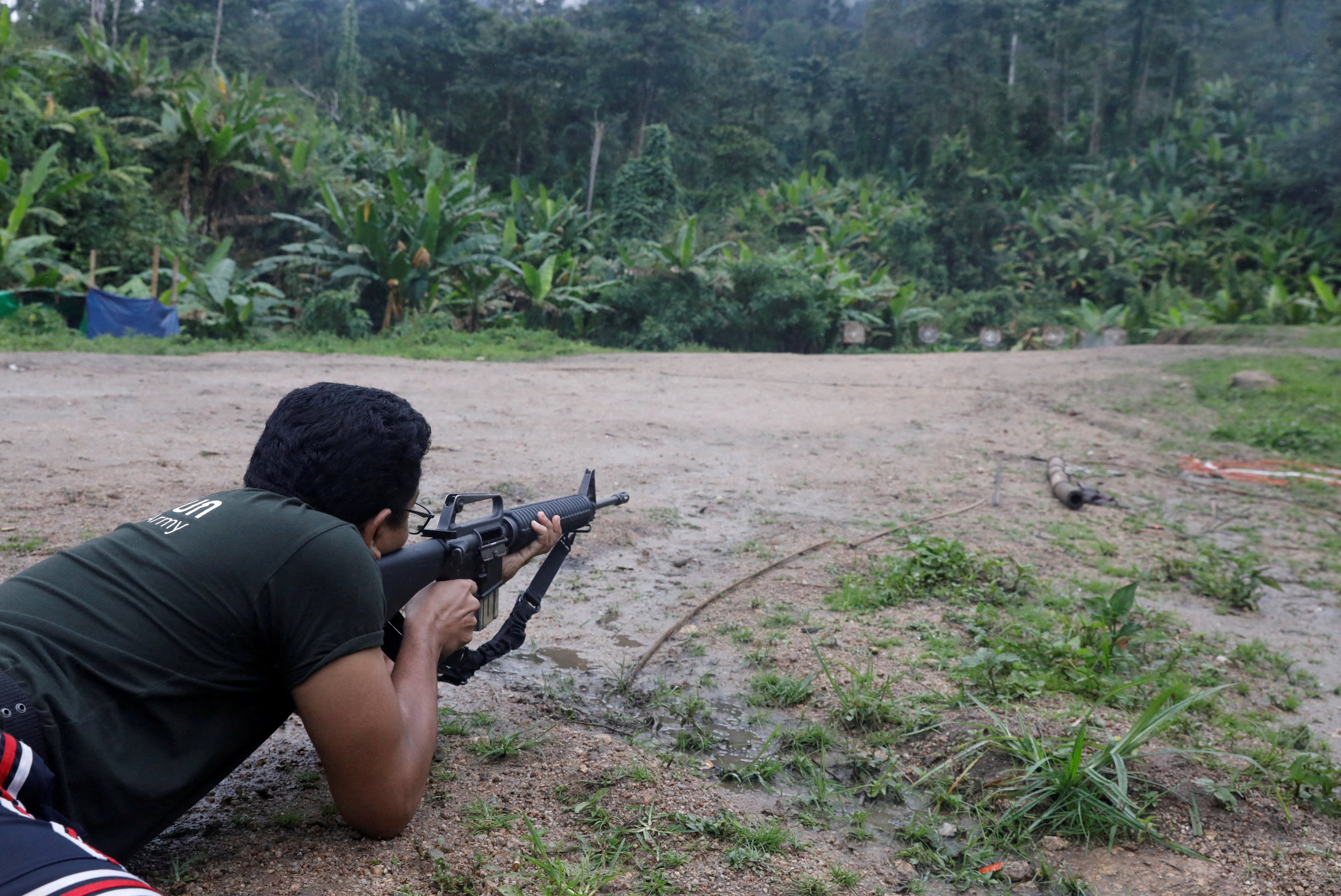 Sithu Maung, an elected member of parliament in the 2020 election, aims a gun at a training camp in an area controlled by ethnic Karen rebels, Karen State, Myanmar. Photo: Reuters/File