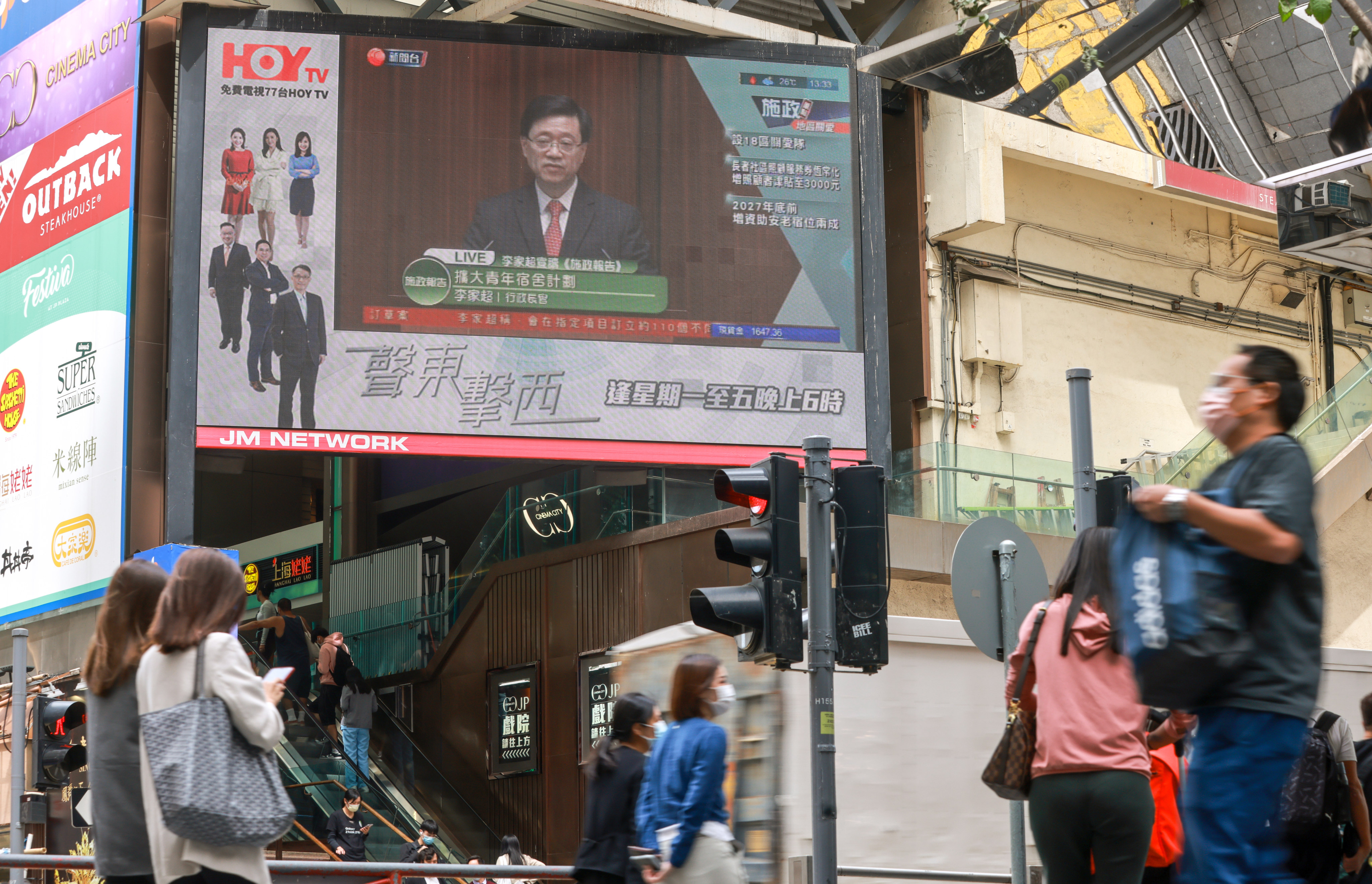 A giant screen shows a HOY TV report on Hong Kong Chief Executive John Lee Ka-chiu. Photo May Tse