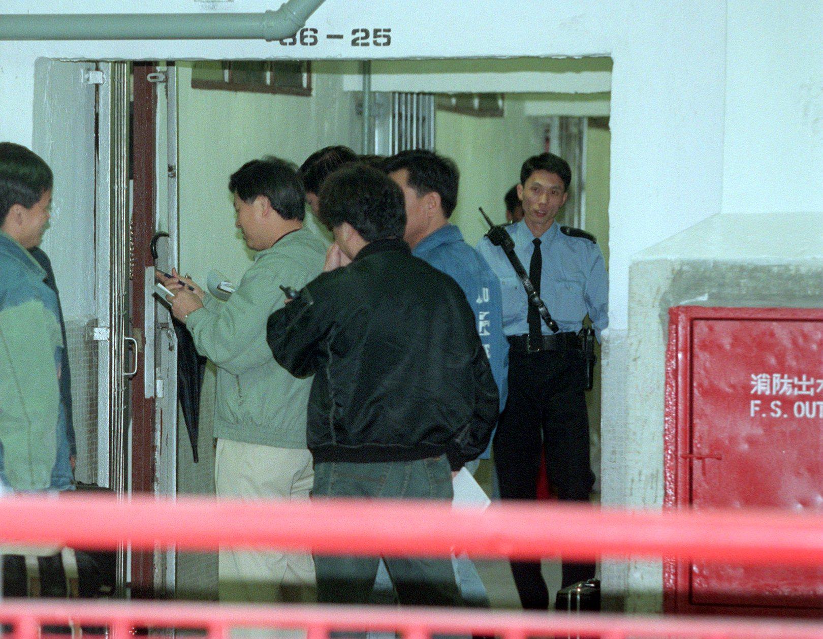 Hong Kong police at the door of a flat inside which they found a man’s dismembered body in a trunkful of salt. His common-law wife was later convicted of manslaughter and sentenced to 10 years in prison. Photo: SCMP