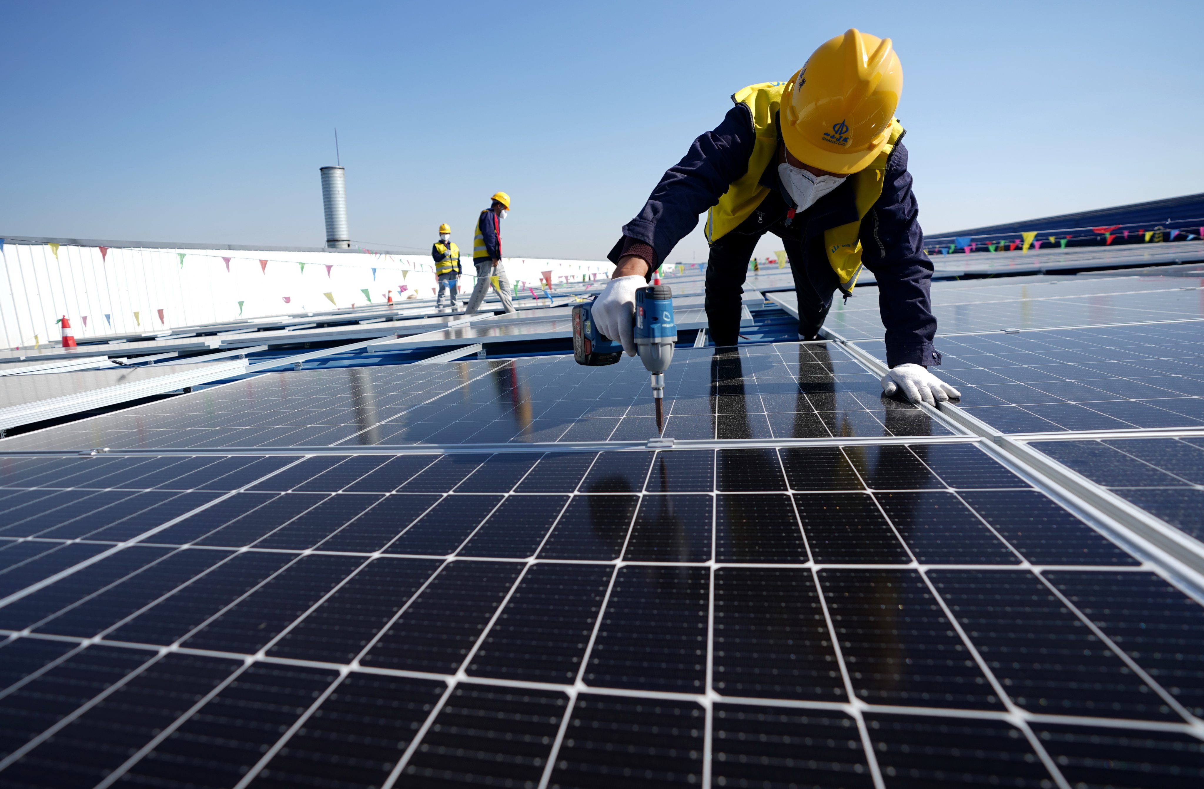 A worker installs photovoltaic power panels on a roof in Tangshan, Hebei province. China makes and supplies more than 80 per cent of the world’s photovoltaic panels, according to the International Energy Agency. Photo: Xinhua