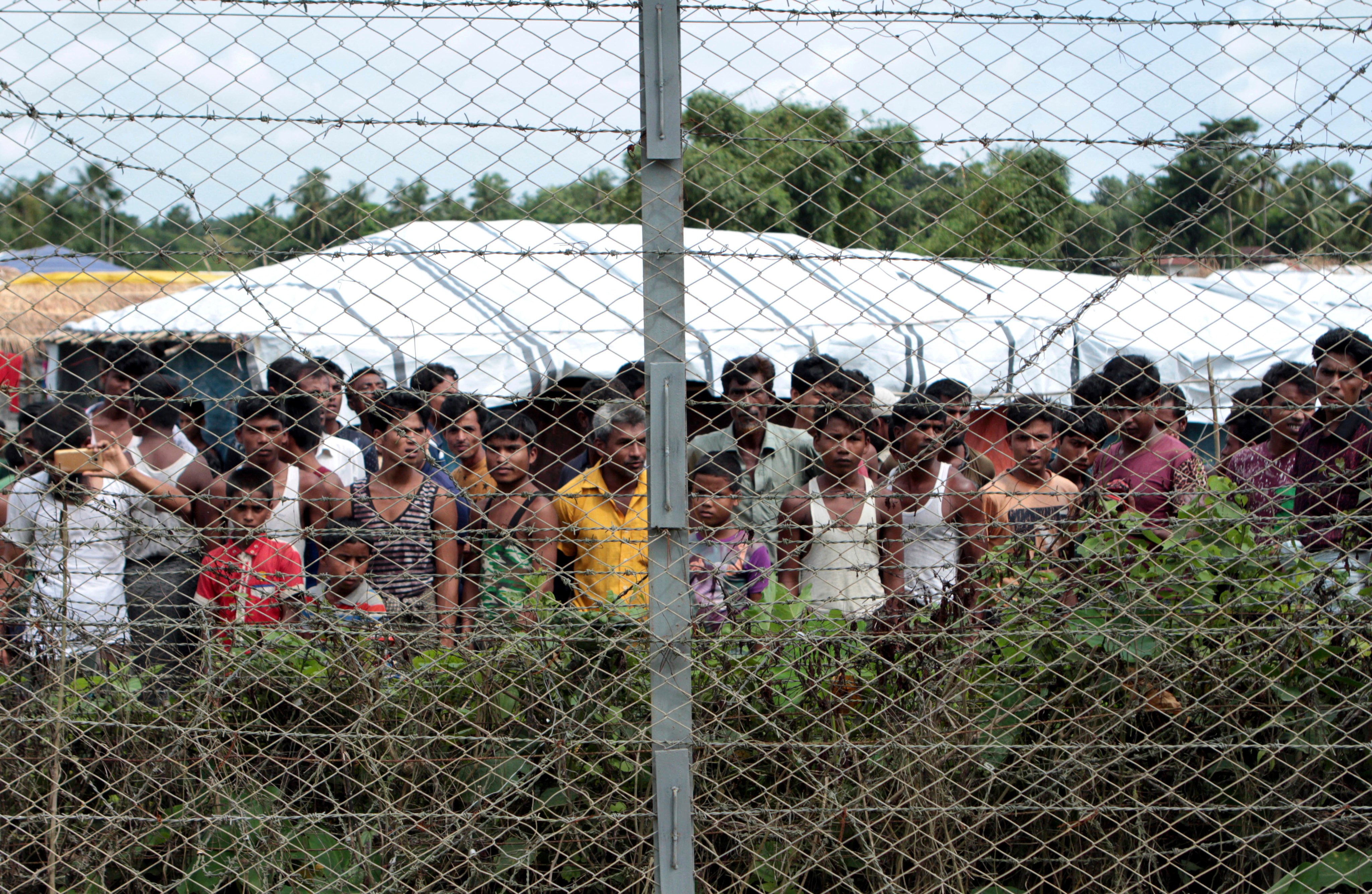 Rohingya refugees gather near a fence at a no-man’s land between Myanmar and Bangladesh. Photo: AP
