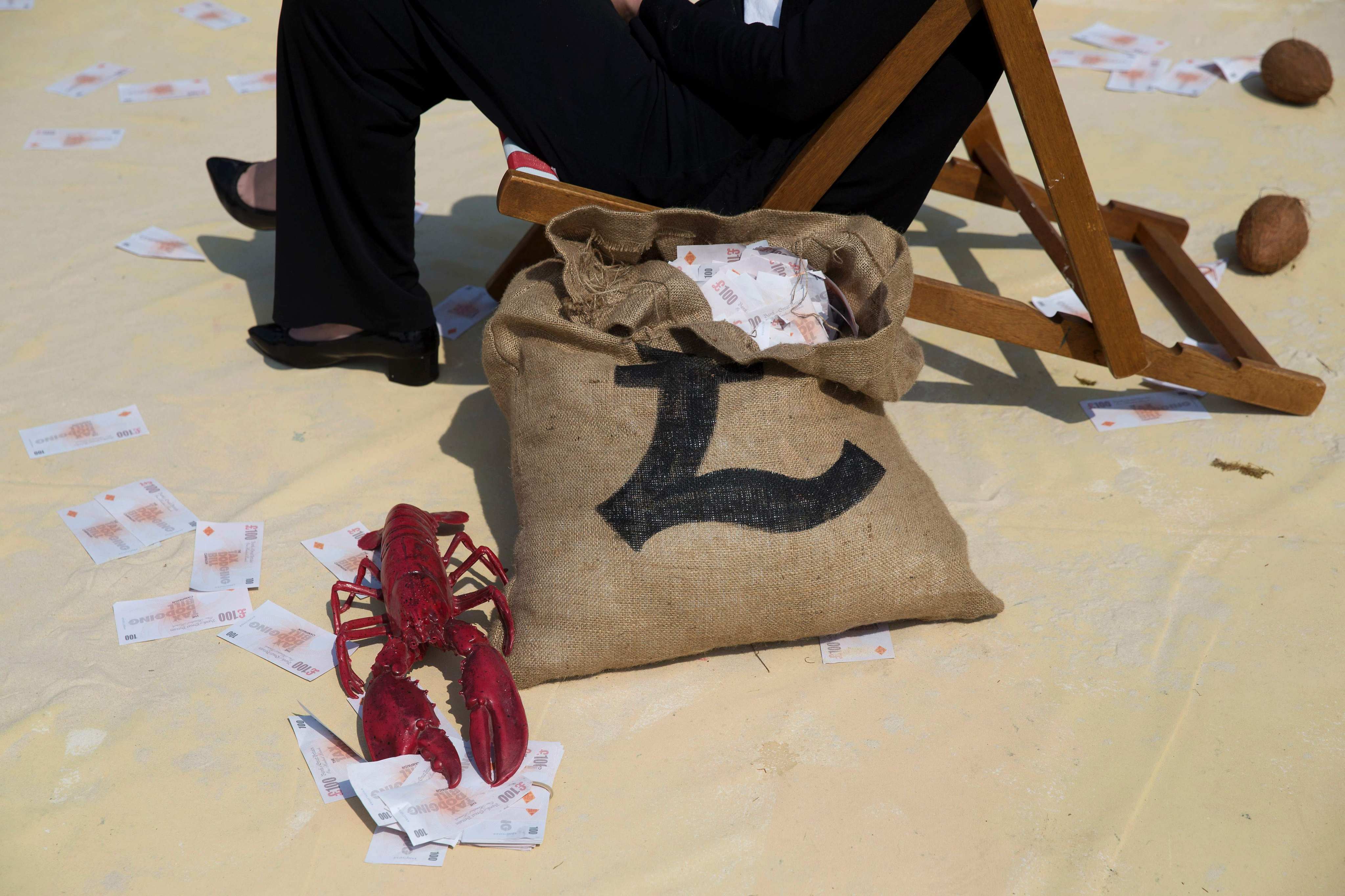 A demonstrator dressed in business attire protests against tax avoidance at a “tropical tax haven” in London on May 12, 2016. Western governments are missing a chance to achieve fairer taxation, reduce inequality, curb corruption and remove threats to global stability by not closing down offshore tax havens. Photo: AFP