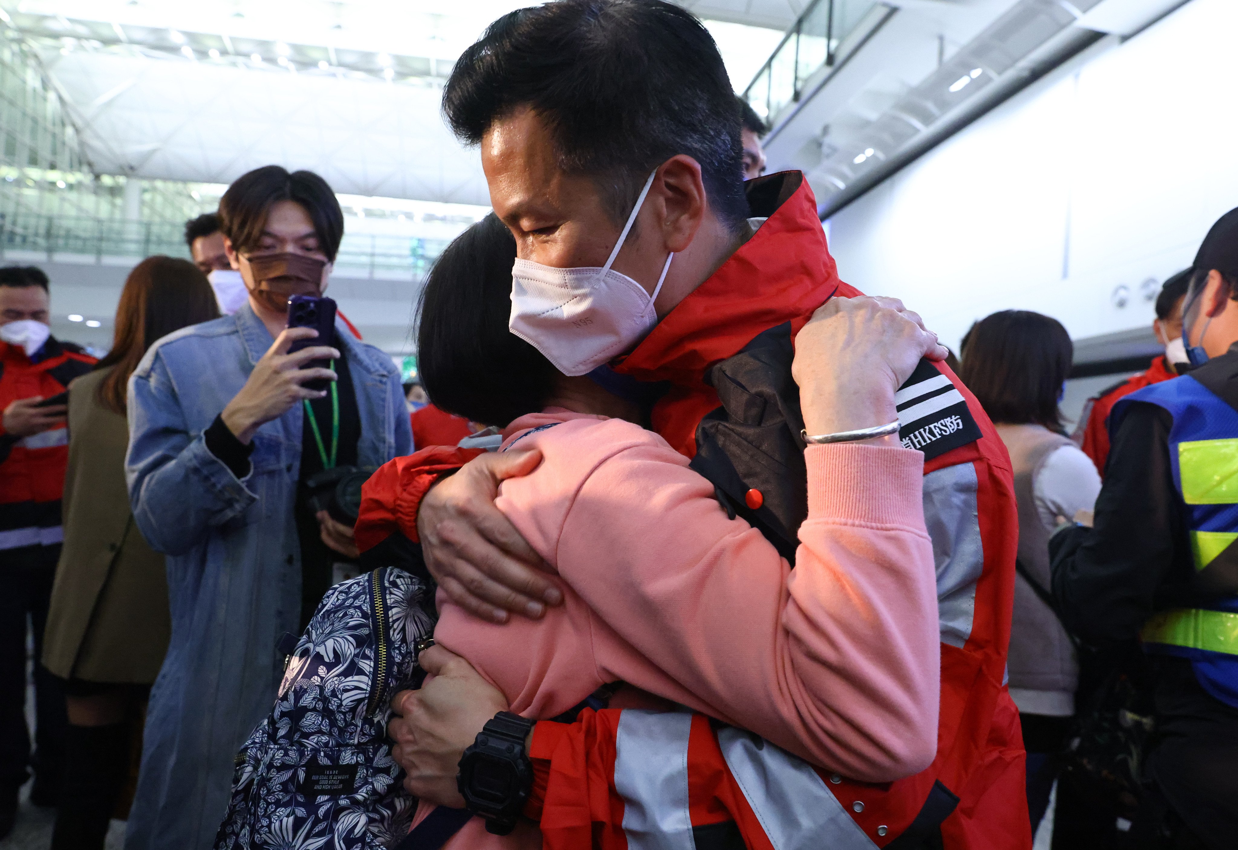 A member of Hong Kong’s 59-strong rescue team embraces a loved-one on return to the city on Friday night. Photo: Dickson Lee