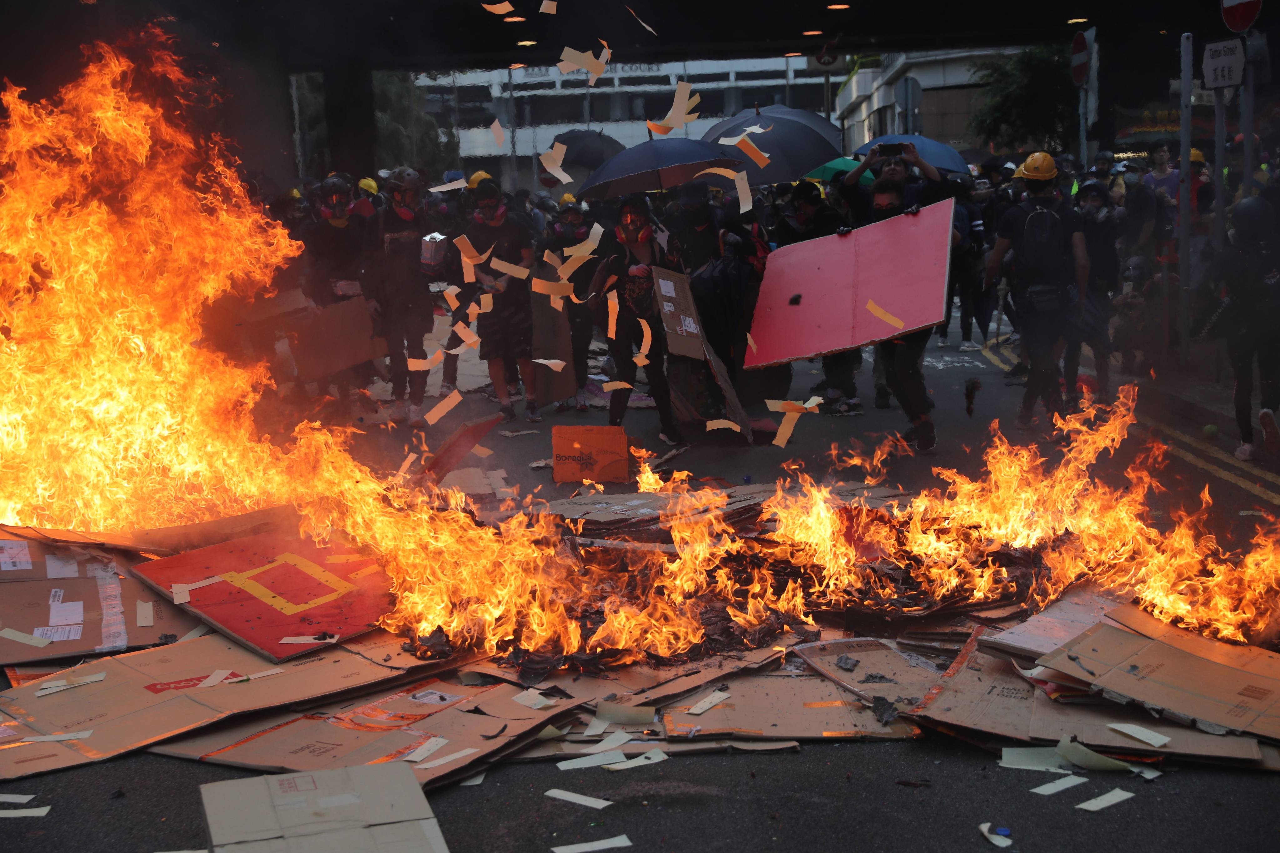 Anti-government protesters set fire and toss paper offerings in the air on Tamar Street, in Admiralty. Photo: Sam Tsang