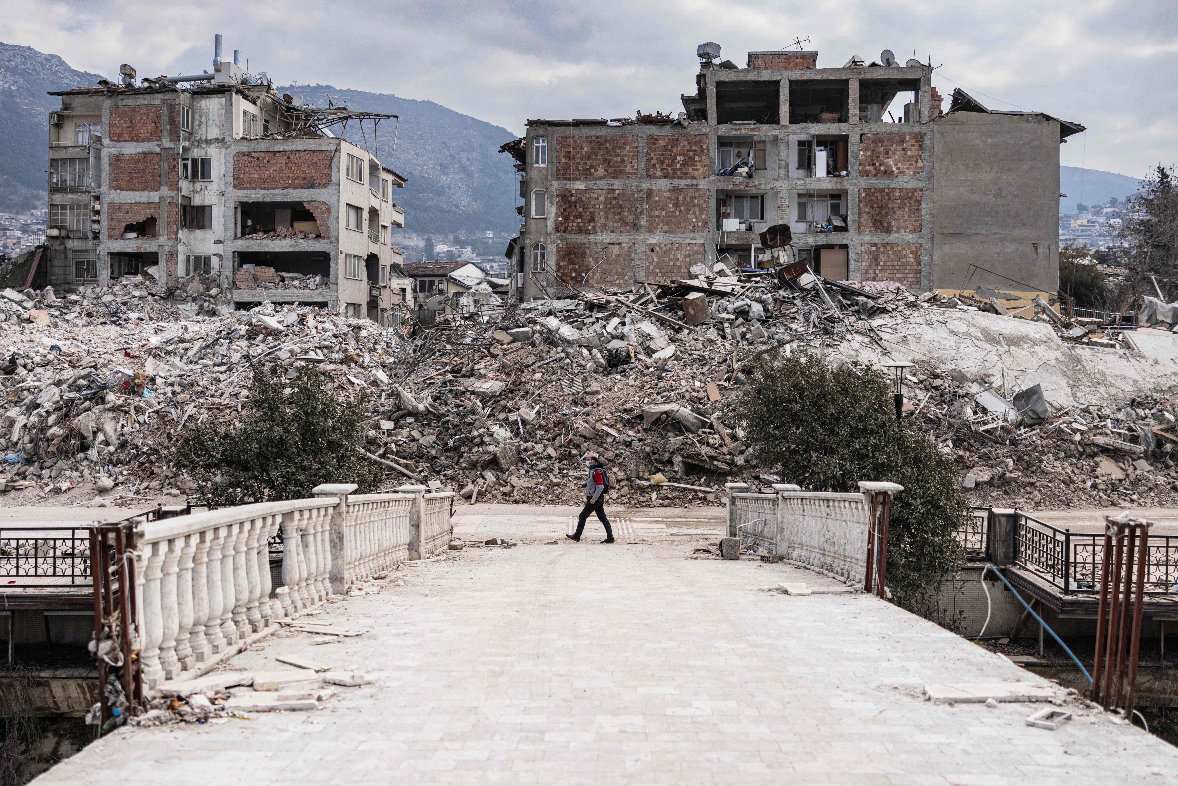 A man walks in front collapsed buildings in the city of Antakya. Photo: AFP