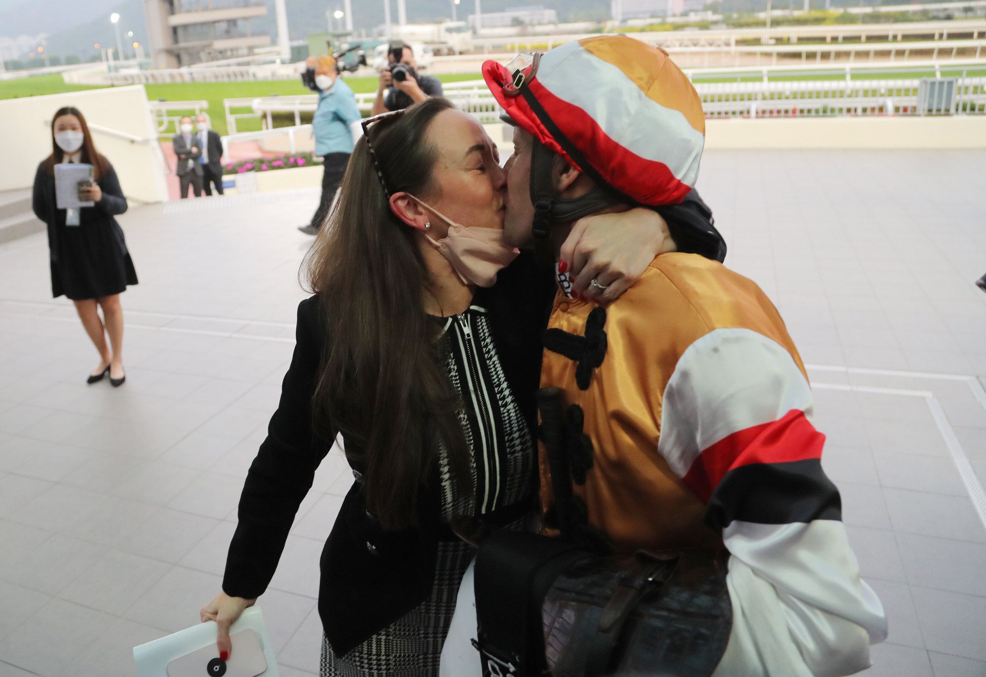 Hugh Bowman gets a kiss from wife Christine after completing his treble at Sha Tin on Sunday.