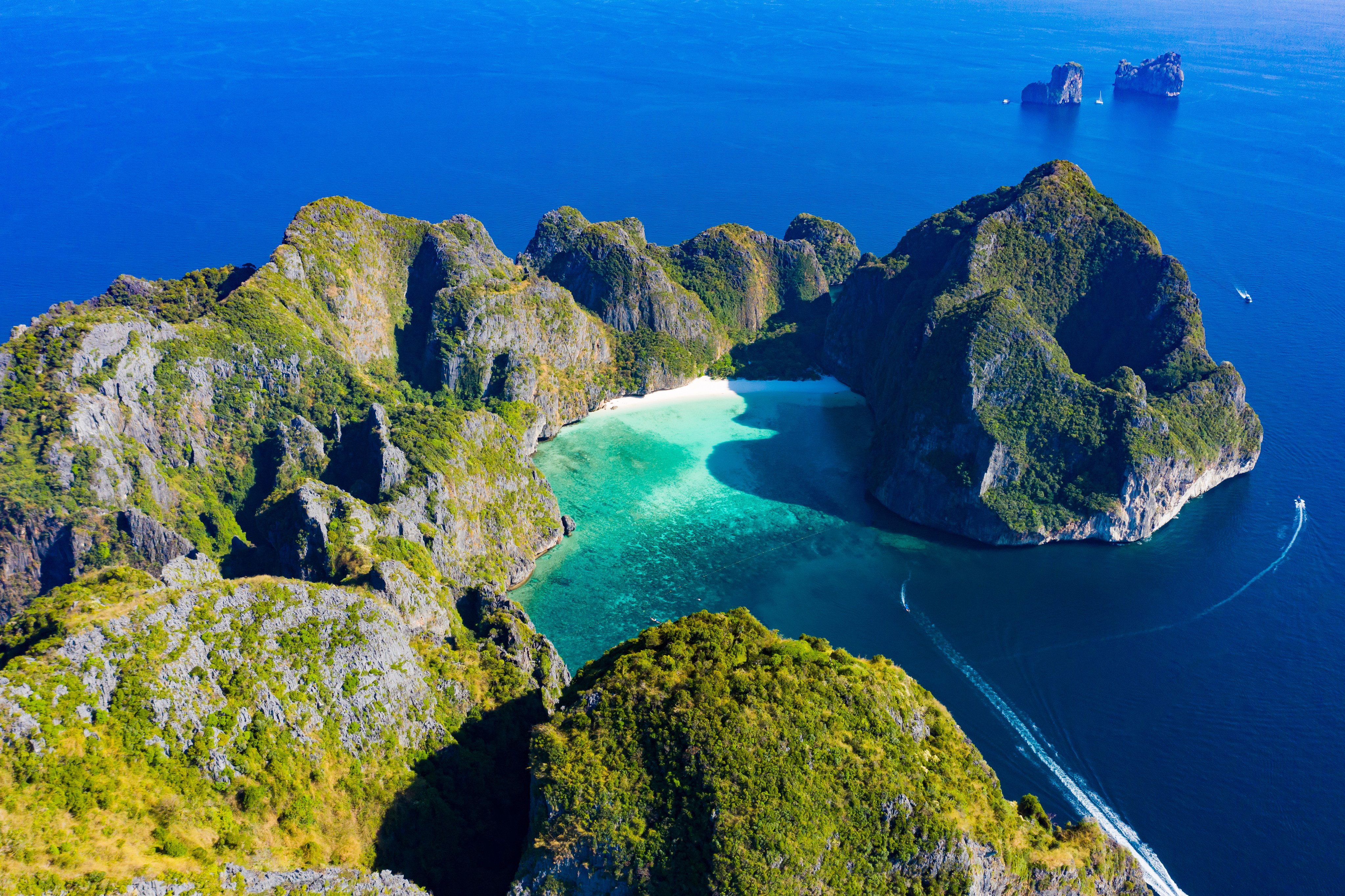 A stunning aerial view of Koh Phi Phi Lee with the beautiful beach of Maya Bay bathed by a turquoise clear water. Amazing limestone karst formations surround this island in Thailand. Photo: Shutterstock