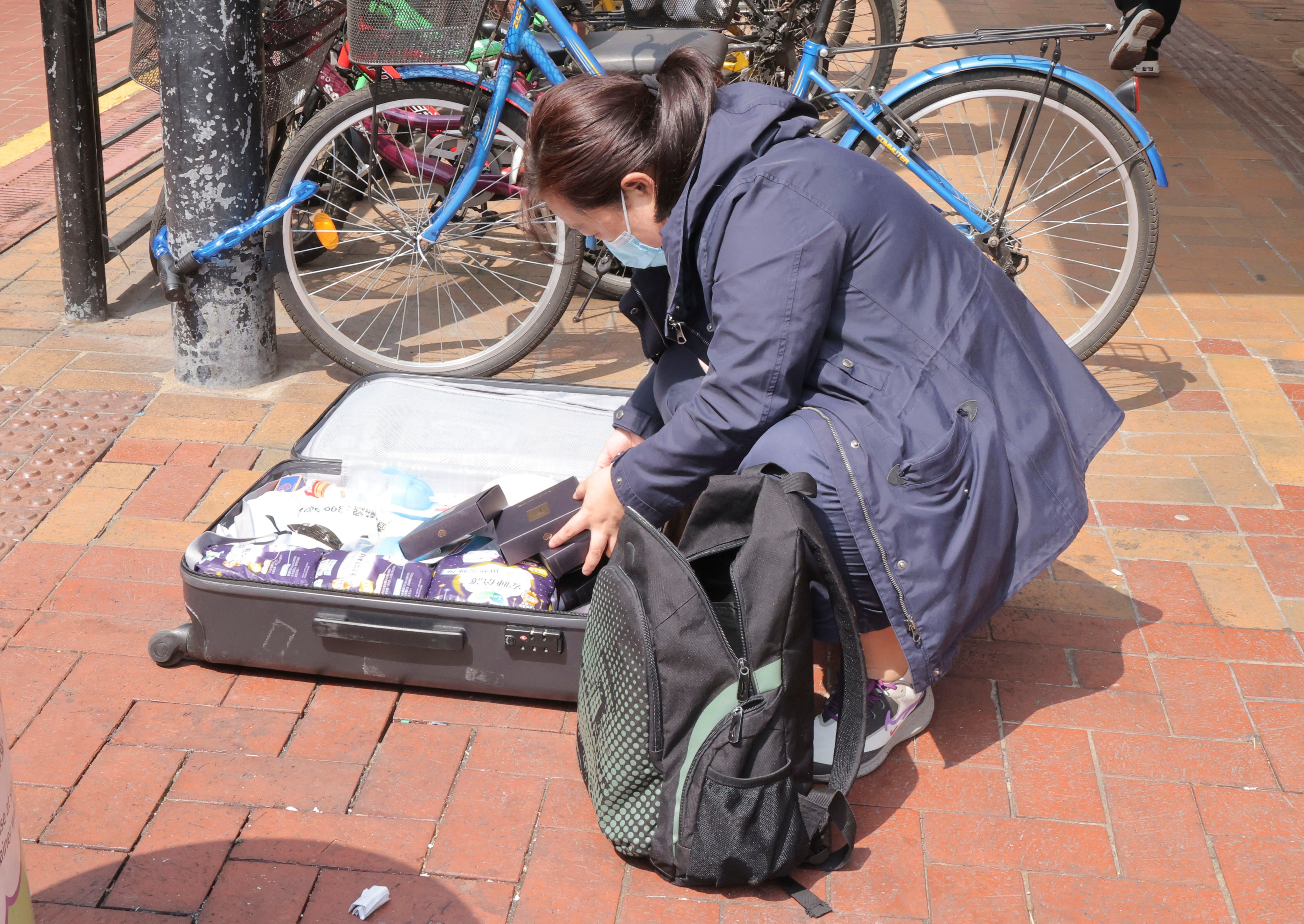 A woman stuffs her suitcase with goods at Sheung Shui, where parallel traders and couriers have gathered. Photo: Jelly Tse