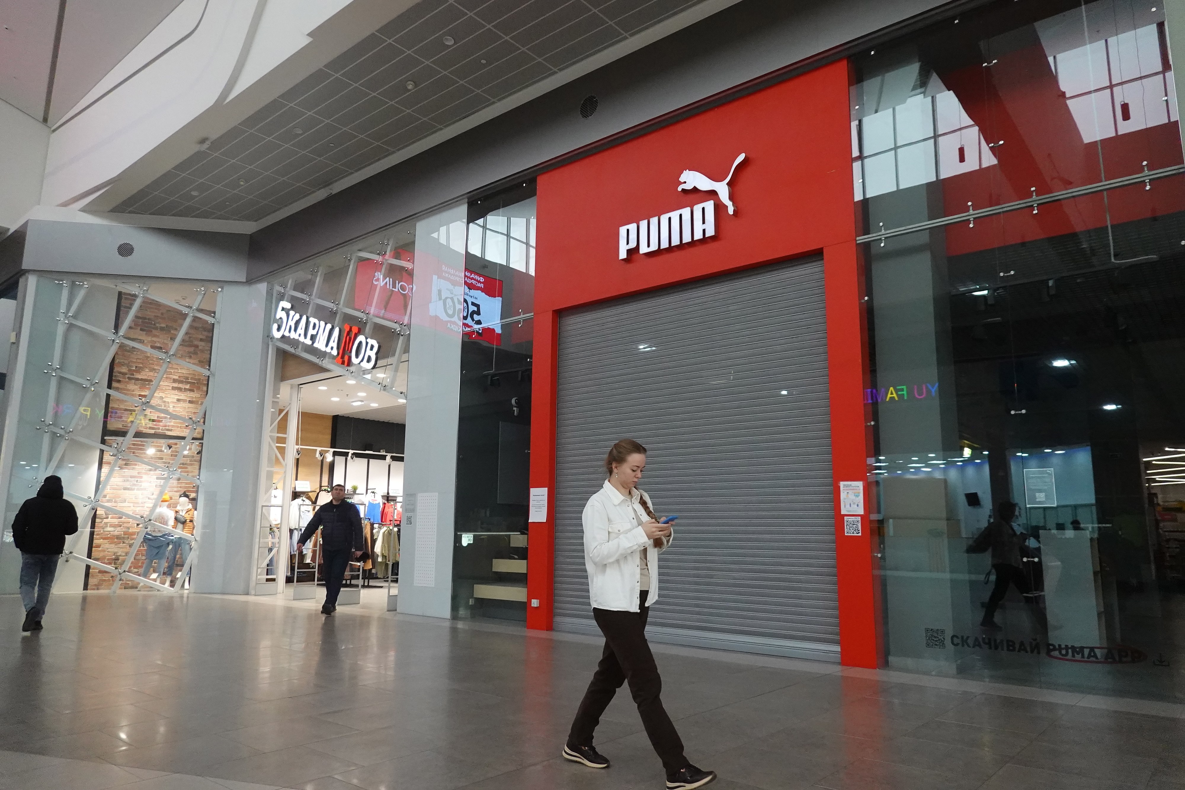 Customers walk in front of a closed Puma store at a shopping centre in Moscow on February 16. As part of the economic sanctions imposed by the West on Russia, Puma and a number of other international brands announced the suspension, limitation or closing of their operations in Russia. Photo: EPA-EFE