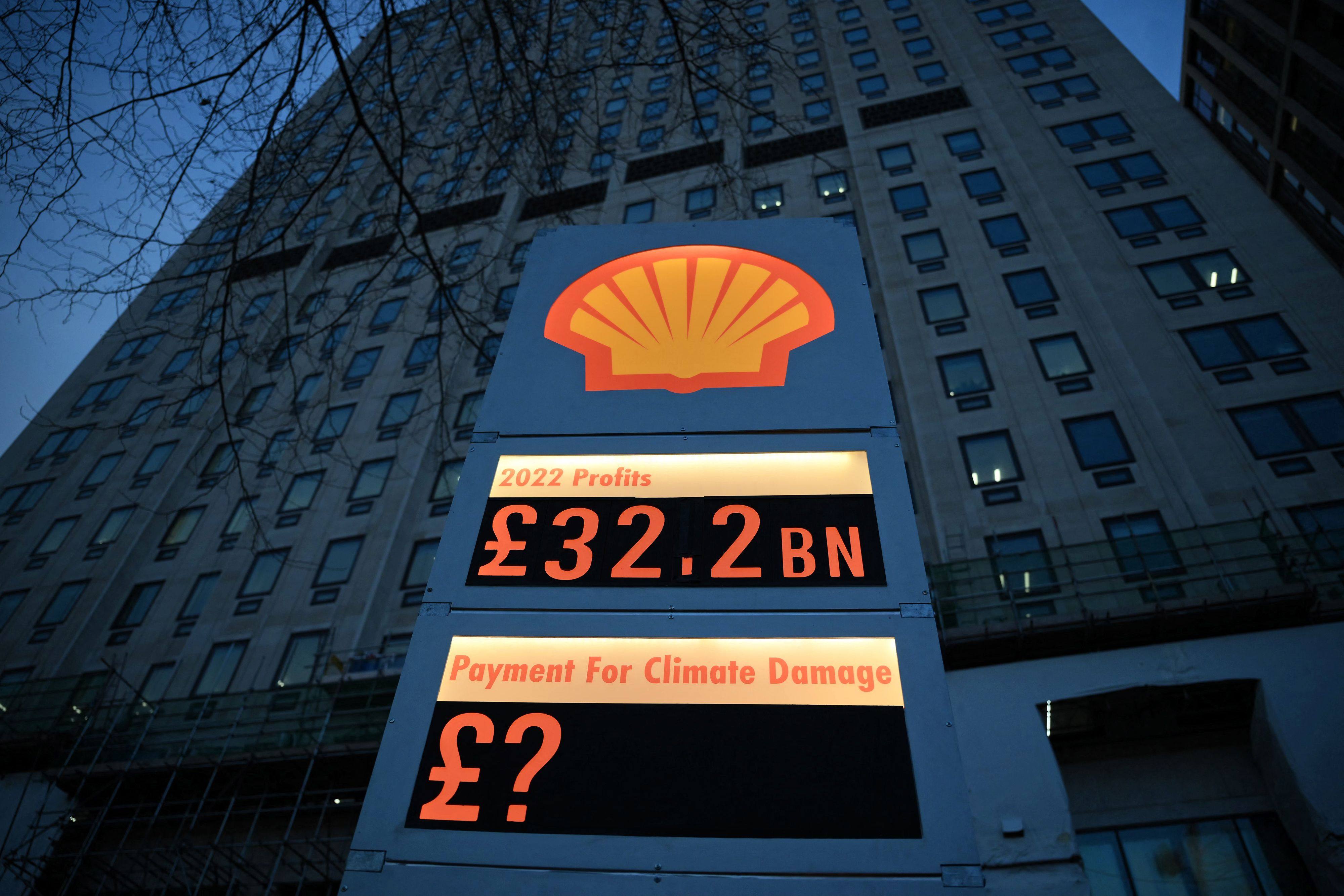 Activists from Greenpeace set up a mock petrol station price board displaying Shell’s net profit for 2022 as they demonstrate outside the company’s headquarters in London on February 2. Oil companies should use their financial clout to accelerate the transition towards renewable energy. Photo: AFP