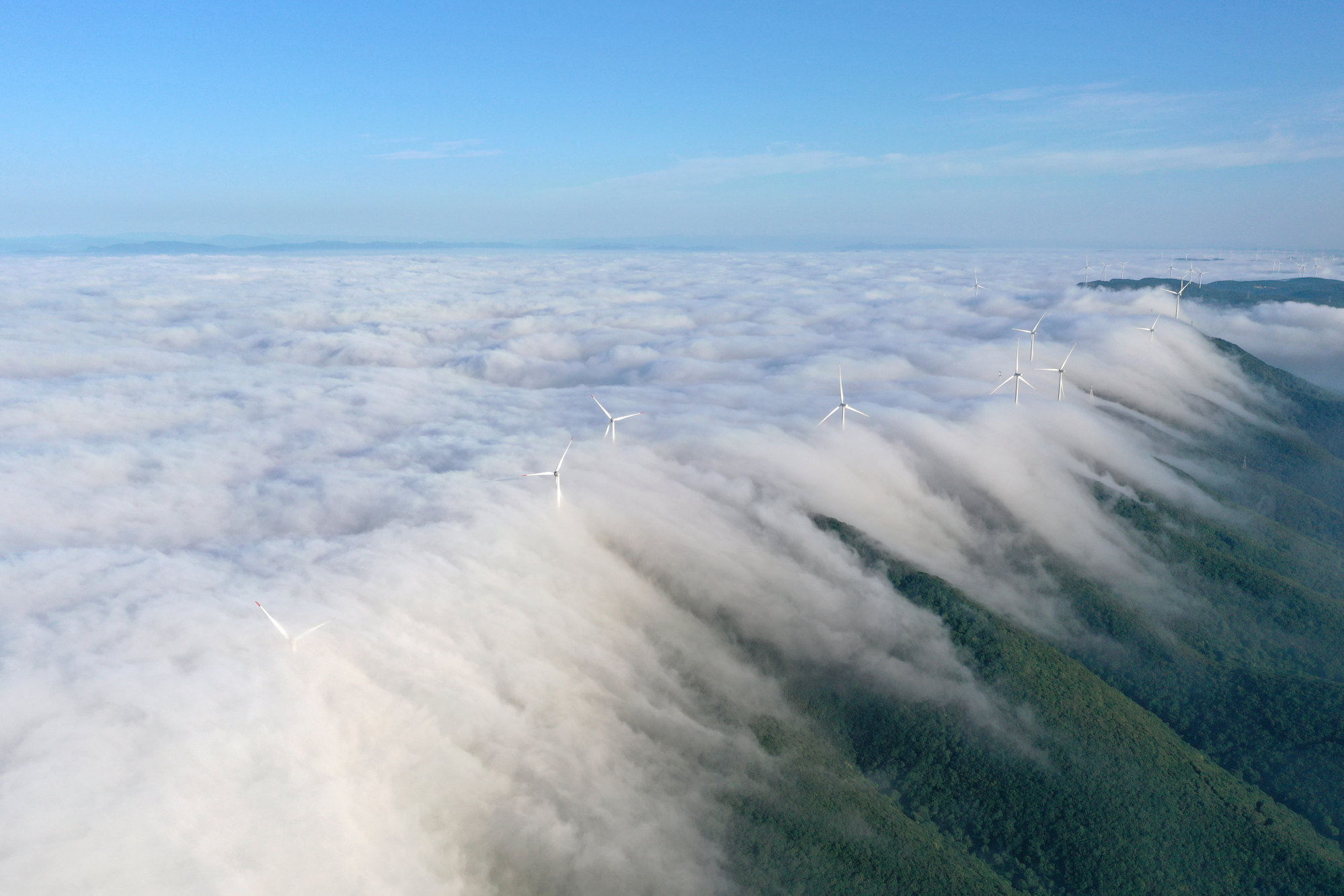 Wind turbines are seen amid sea of clouds in Jingmen, central China’s Hubei province, on May 29 last year. Renewable energy will meet over 70 per cent of China’s additional electricity demand in the next three years, according to the International Energy Agency’s latest projection. Photo: Xinhua