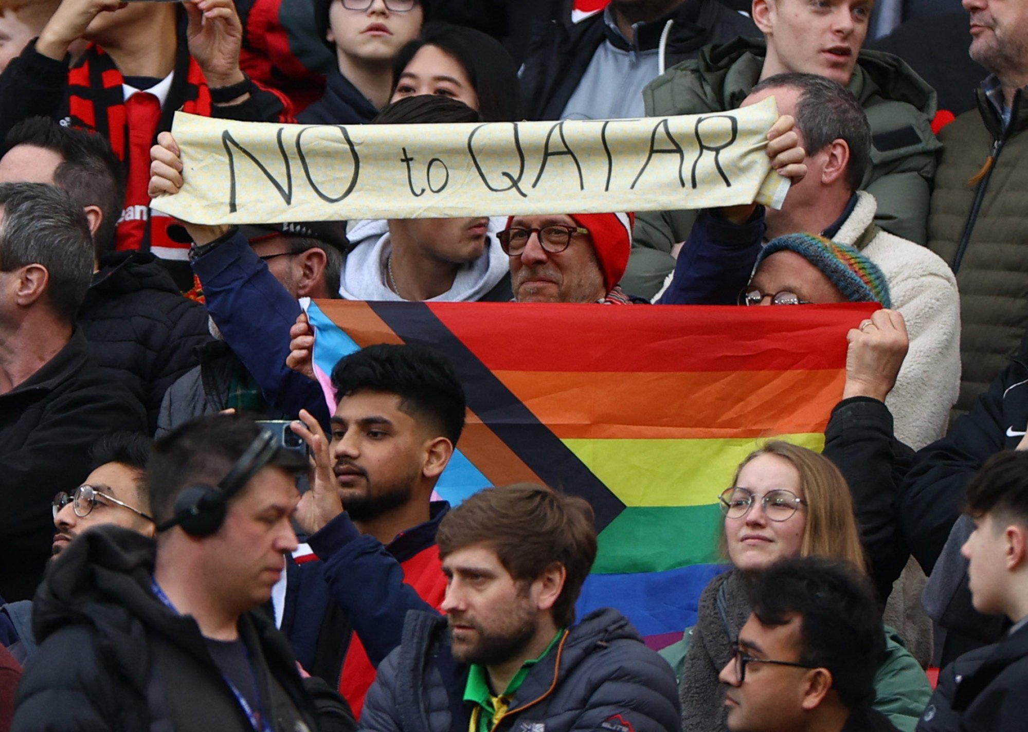 Manchester United fans hold up a ‘No to Qatar’ sign and LGBT flag. Photo: Reuters/FIle