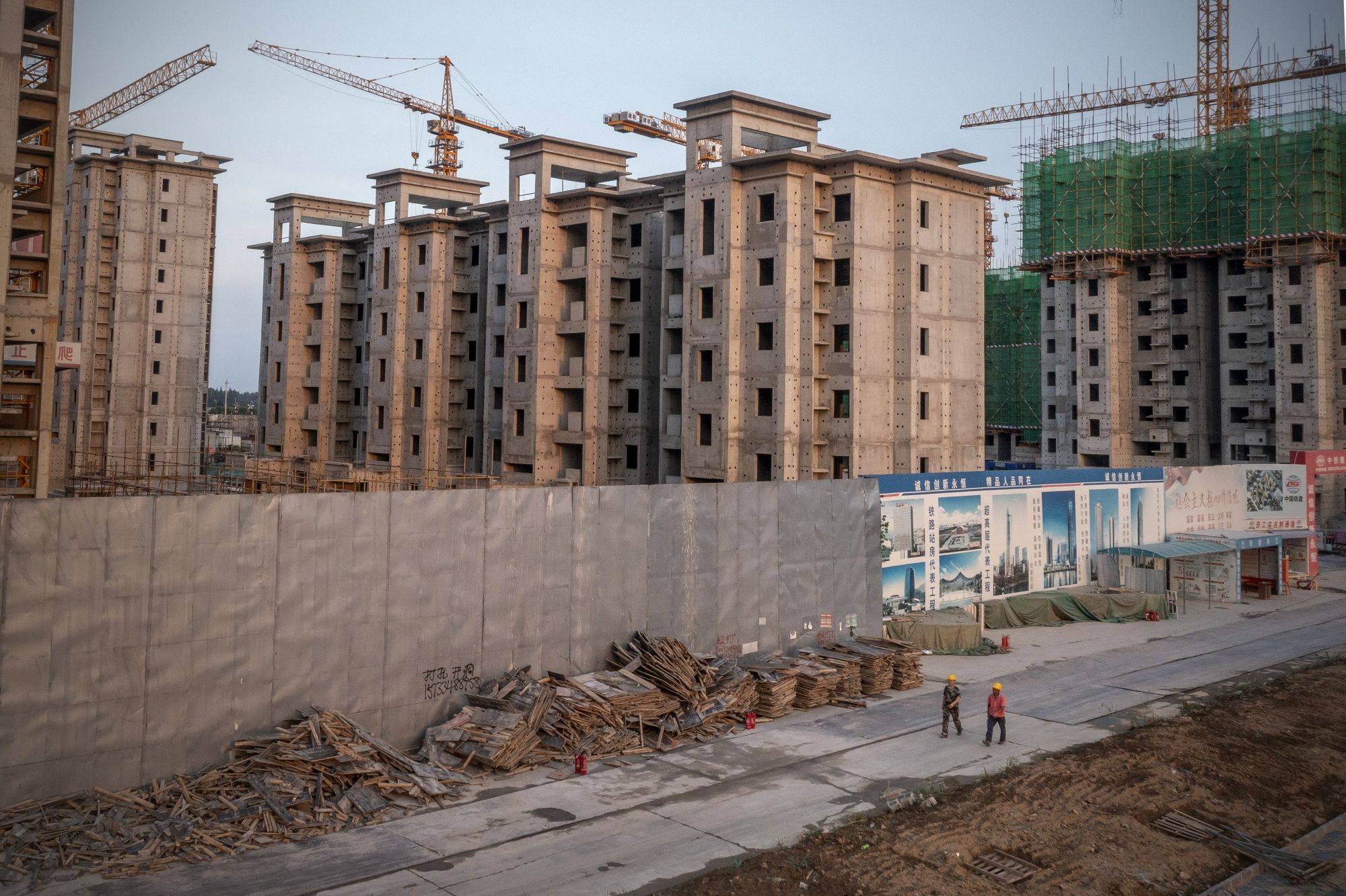 Workers leave the China Evergrande Group Royal Peak residential development under construction in Beijing on July 29, 2022. Photo: Bloomberg