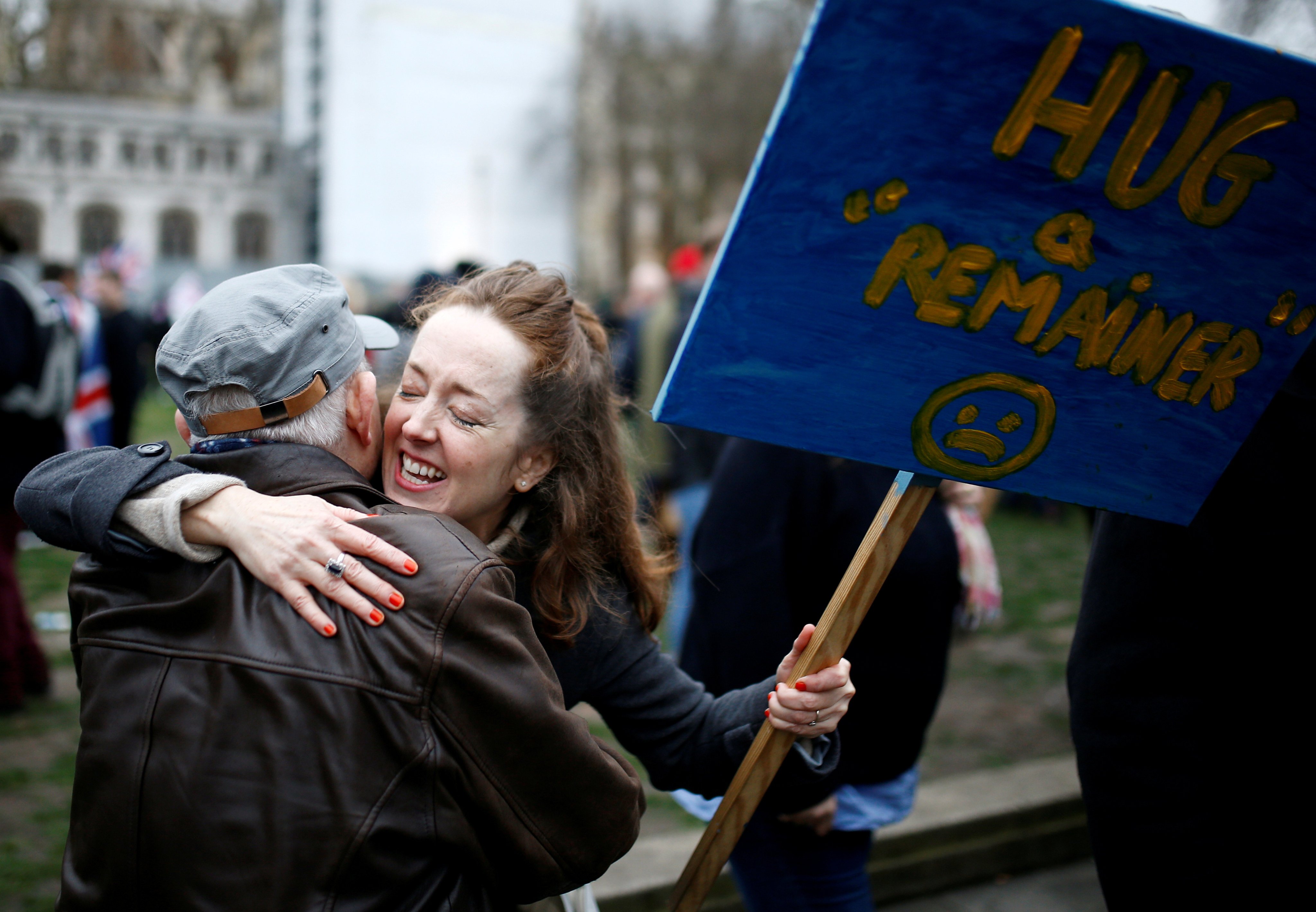 An anti-Brexit protester hugs a man while holding a placard on Brexit day in London, Britain, on January 31, 2020. Photo: Reuters