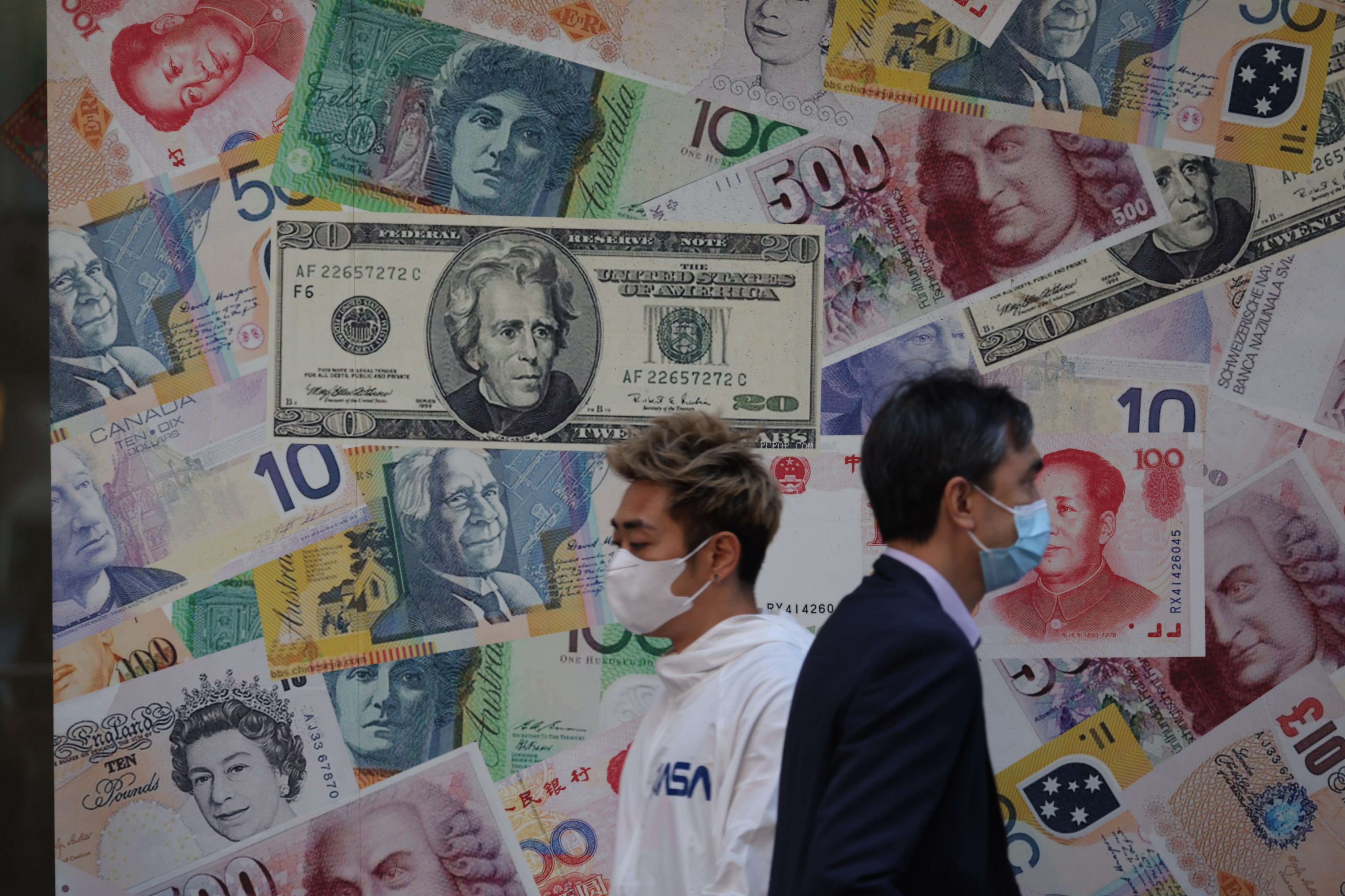 People walk past currency notes displayed outside a currency exchange in Sheung Wan, Hong Kong, in October last year. China’s renminbi could be a clear candidate for investors looking for attractive short dollar currency plays. Photo: Yik Yeung-man