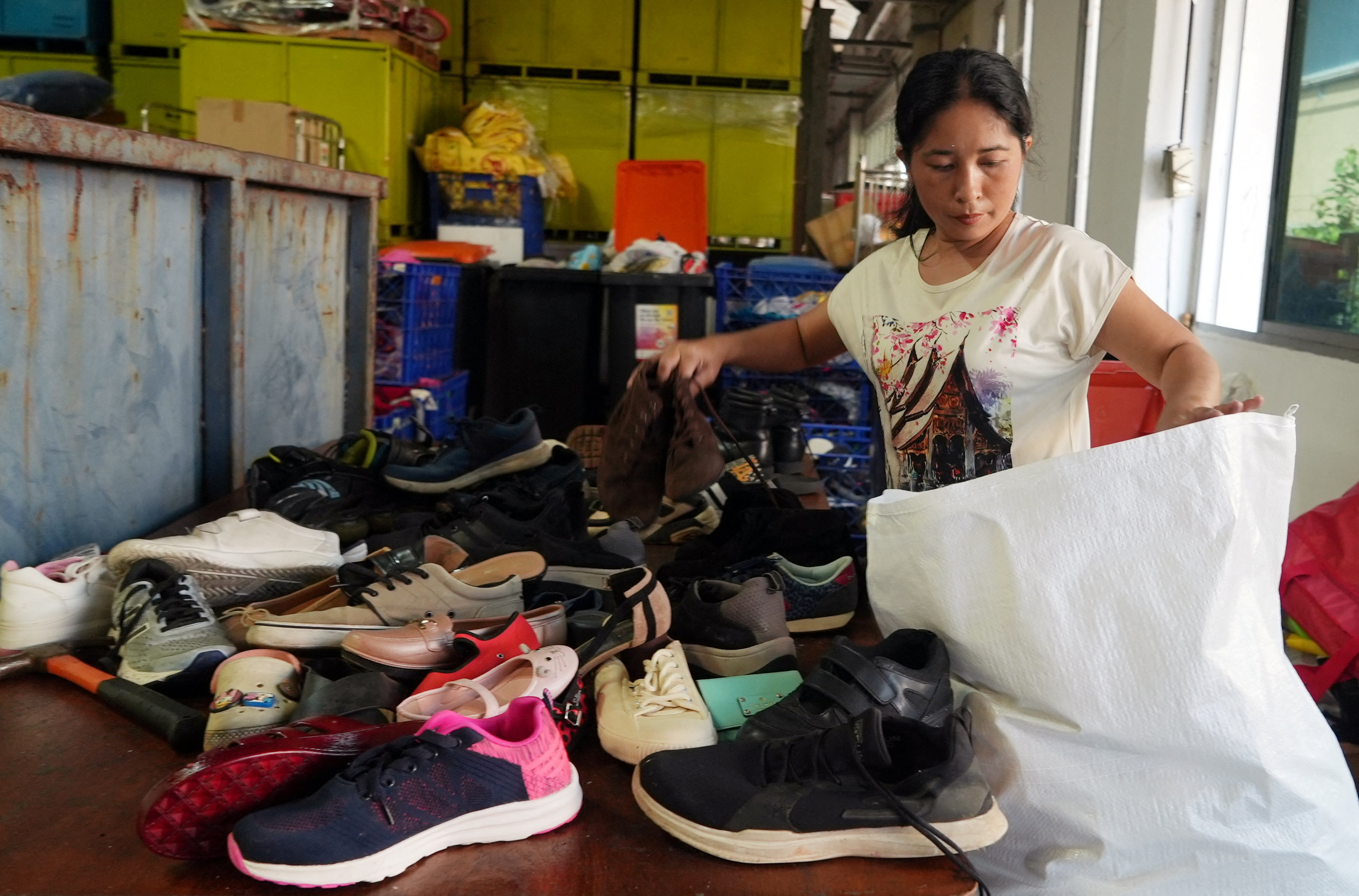 A worker sorts second-hand shoes at a warehouse owned by Yok Impex, a Singaporean textile and shoe trader, last month. Photo: Reuters