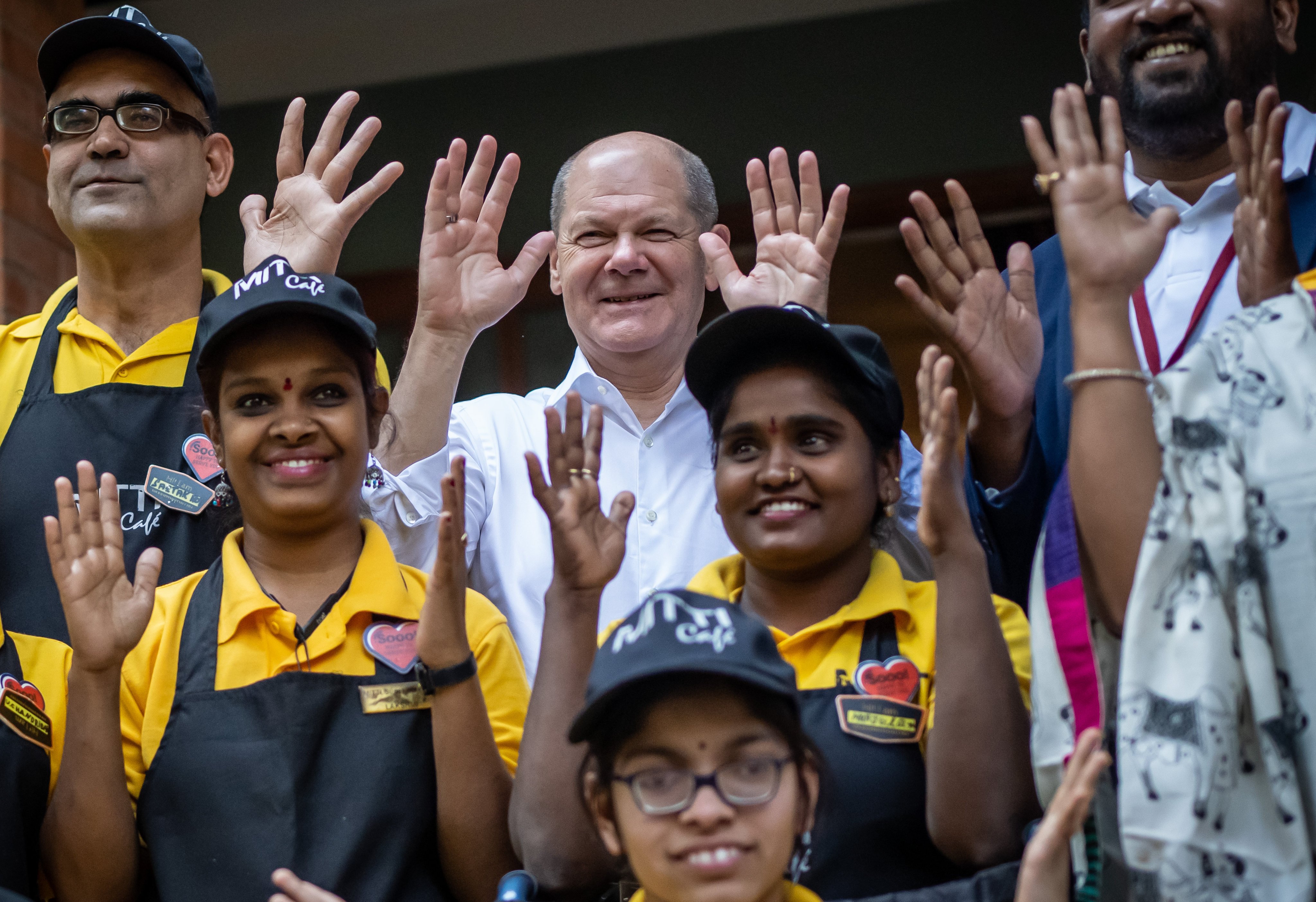 German Chancellor Olaf Scholz, centre, poses for a picture with employees of the Mitti Cafe in Begaluru, India on Sunday. Photo: dpa
