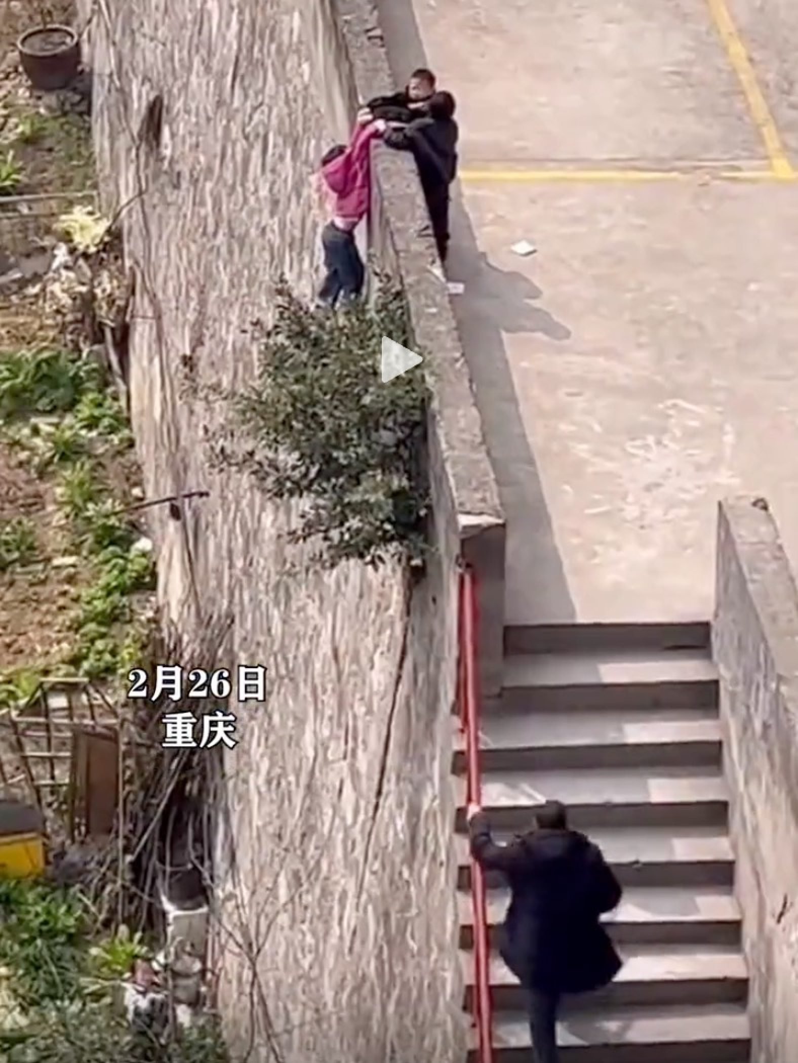 As the youngster holds on for dear life, an adult dashes up the car park stairs to help complete the rescue. Photo: Douyin