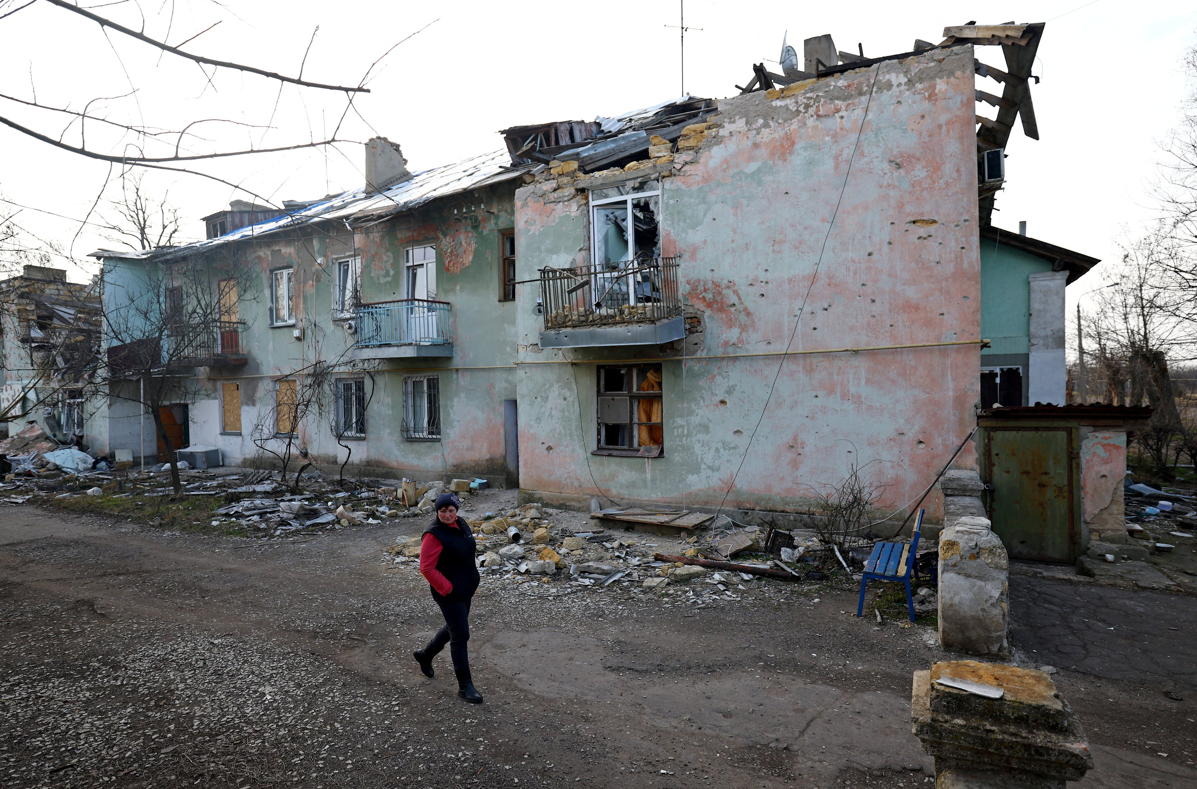 Ukrainian Svitlana Gynzhul walks in front of a damaged house in her village, devastated by shelling at the beginning of Russia’s invasion of Ukraine, in Luch, Mykolaiv region, Ukraine, on February 25. The world is simmering with conflict and resentment. All that’s missing to spark wider war is a trigger. Photo: Reuters