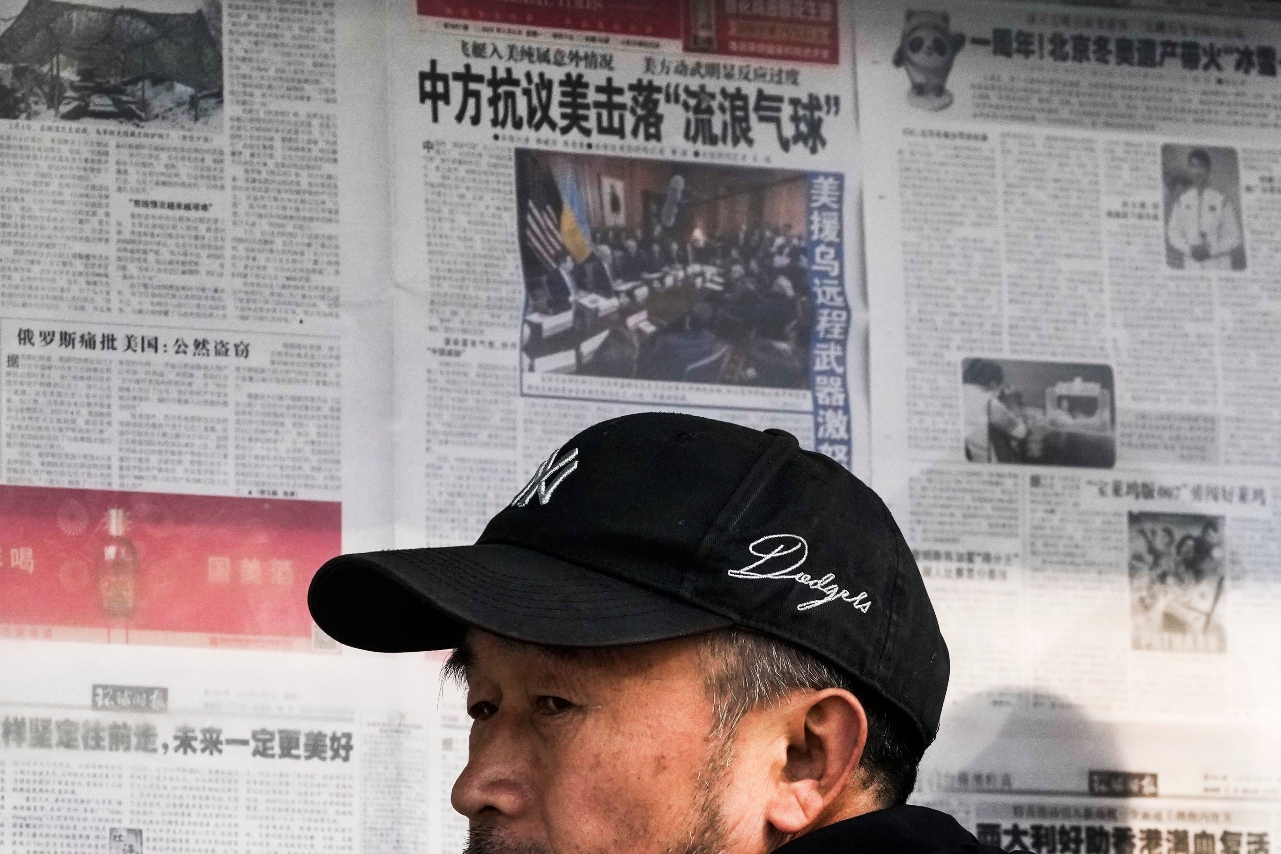 A man reacts after reading a newspaper headline reporting on the US-China balloon incident at a stand in Beijing on February 6. Photo: AP 