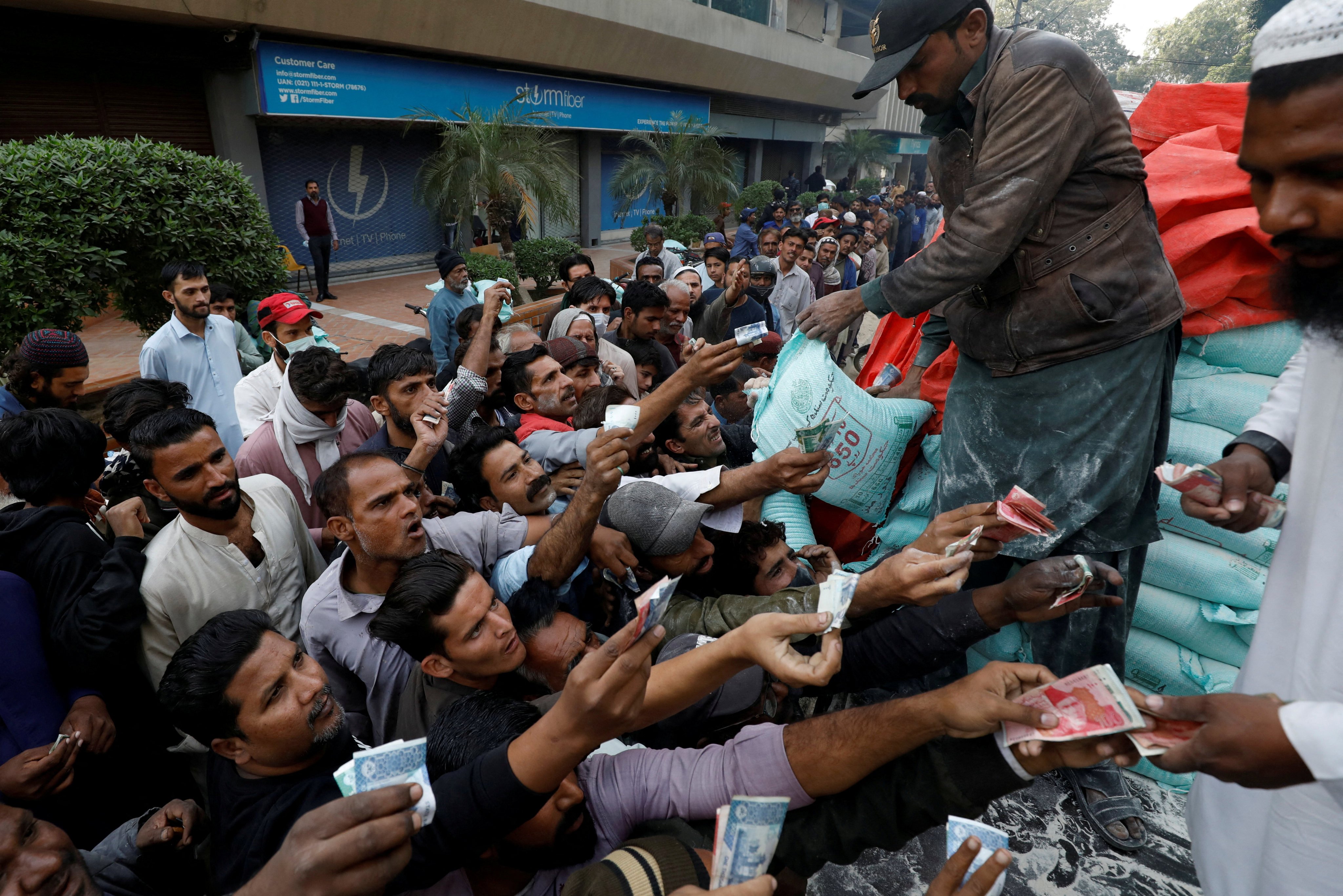 Men reach out to buy subsidised flour sacks from a truck in Karachi, Pakistan. Photo: Reuters/File