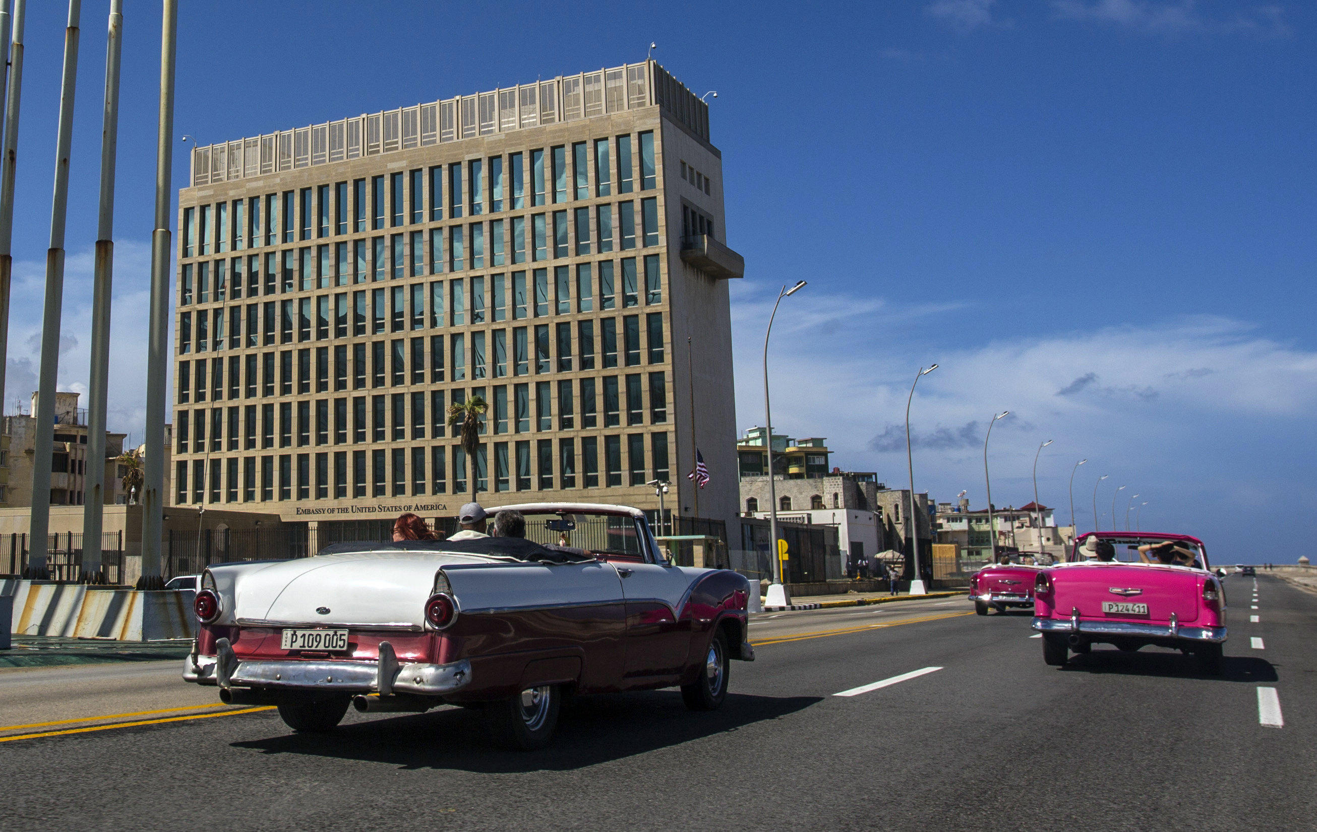 Tourists ride classic convertible cars past the US embassy in Havana, where the first “Havana Syndrome” cases were reported. Photo: AP