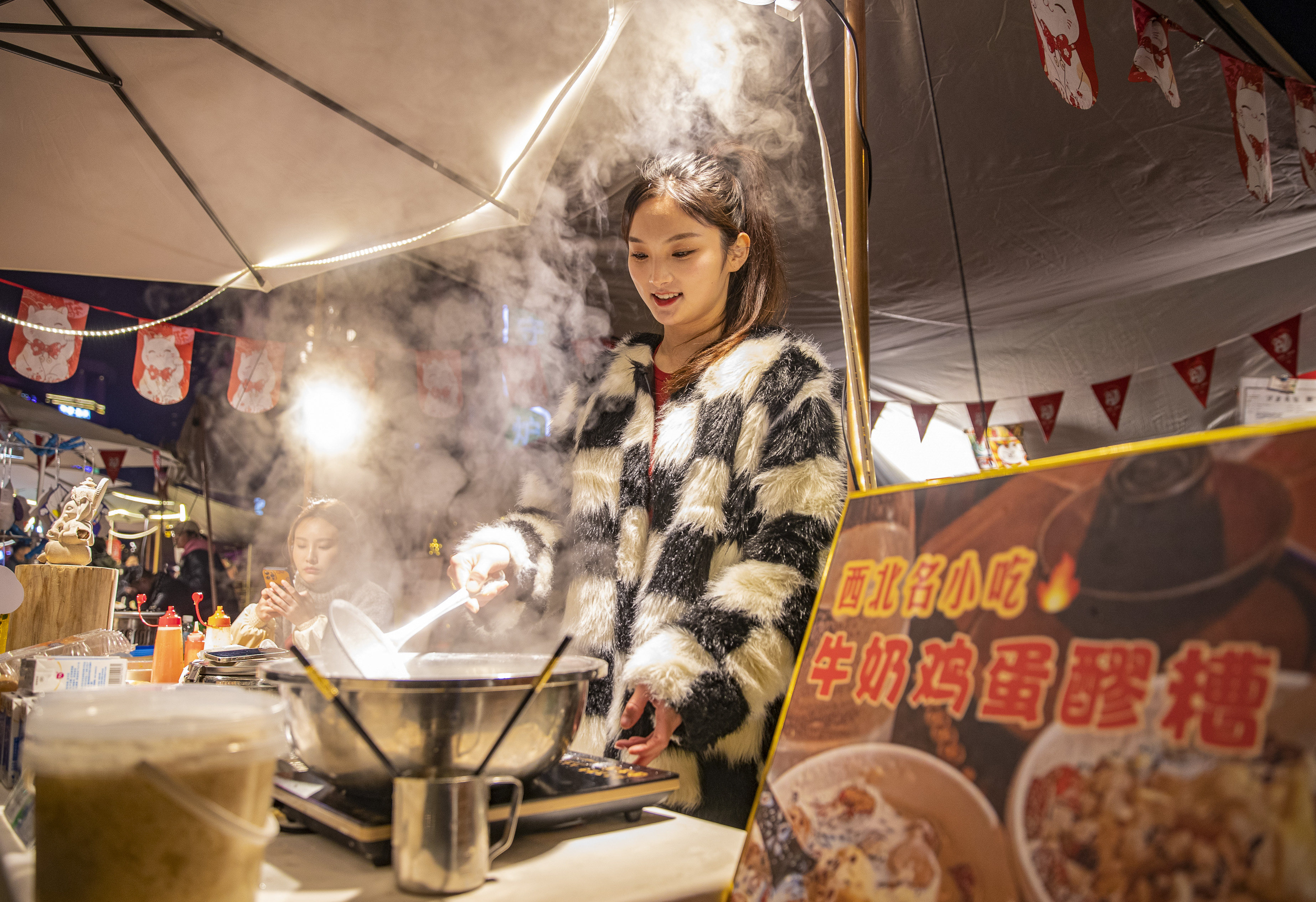 A young vendor cooks at a street stall in China’s Chongqing municipality, which has implemented a variety of nighttime activities this year to boost the so-called night economy. Photo: Xinhua