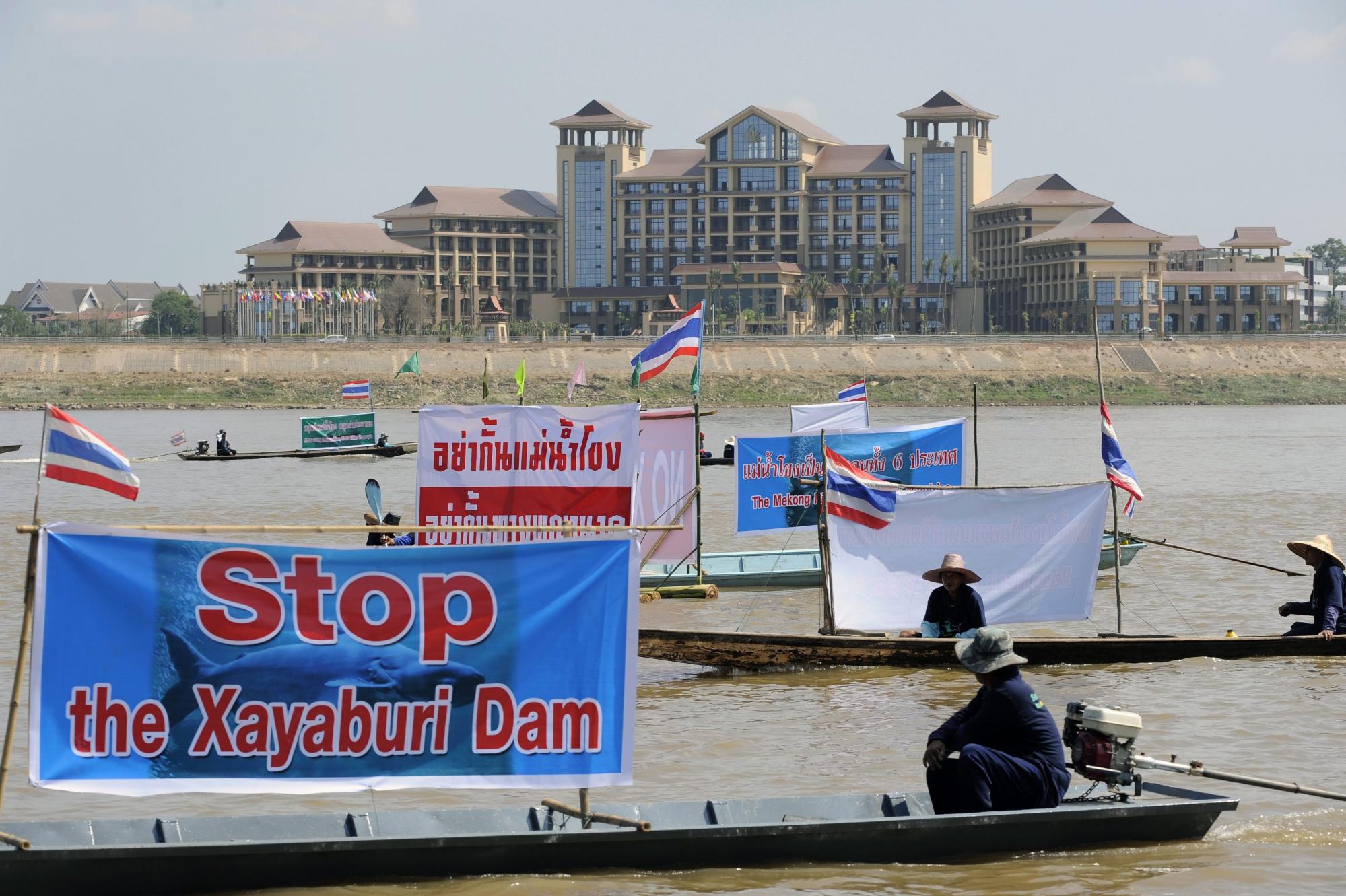 Thai activists and villagers affected by the controversial Xayaburi dam protest while navigating the Mekong river, with Laos territory in the background. Photo: EPA/Handout/File