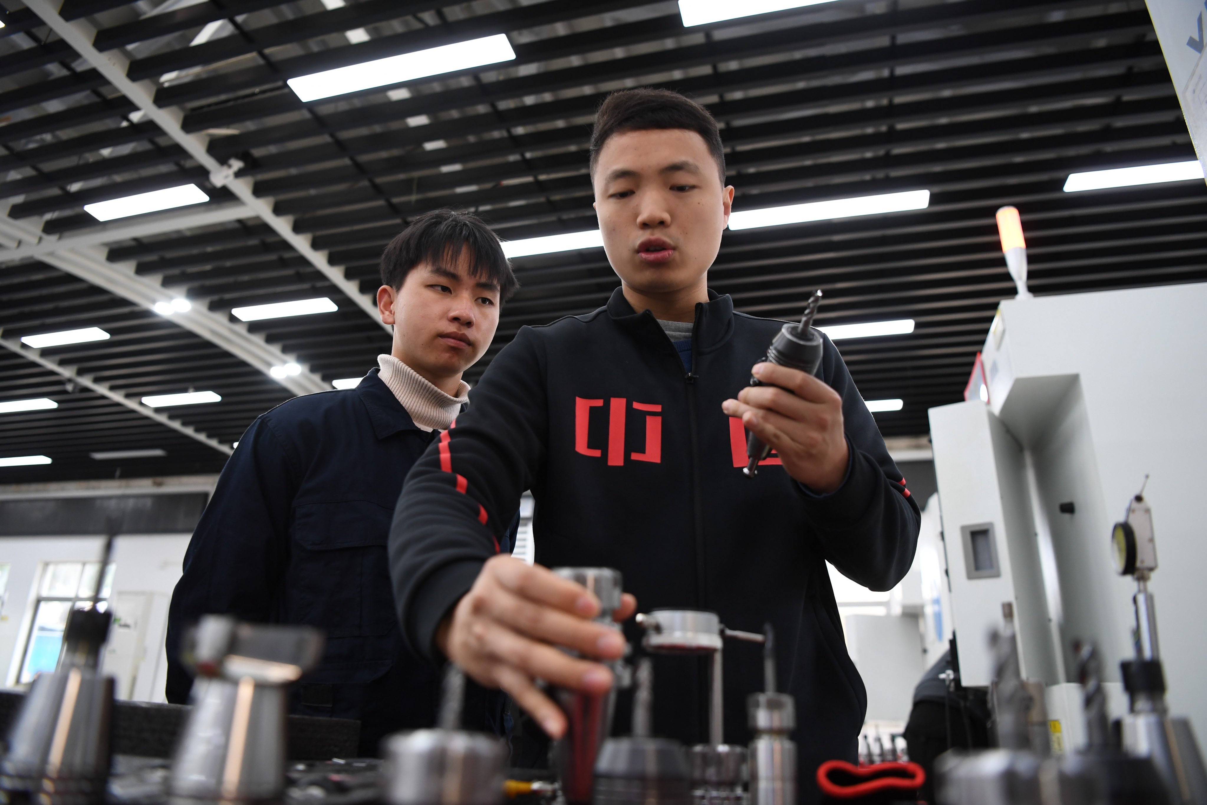Vocational trainer Yang Denghui (right) explains the differences of various cutter heads to a student at Guangdong Machinery Technician College in Guangzhou on February 14. Vocational schools are still regarded by many in China as a place only for students who fail the country’s academic-track high school entry exam, potentially holding back the country’s technological progress. Photo: Xinhua