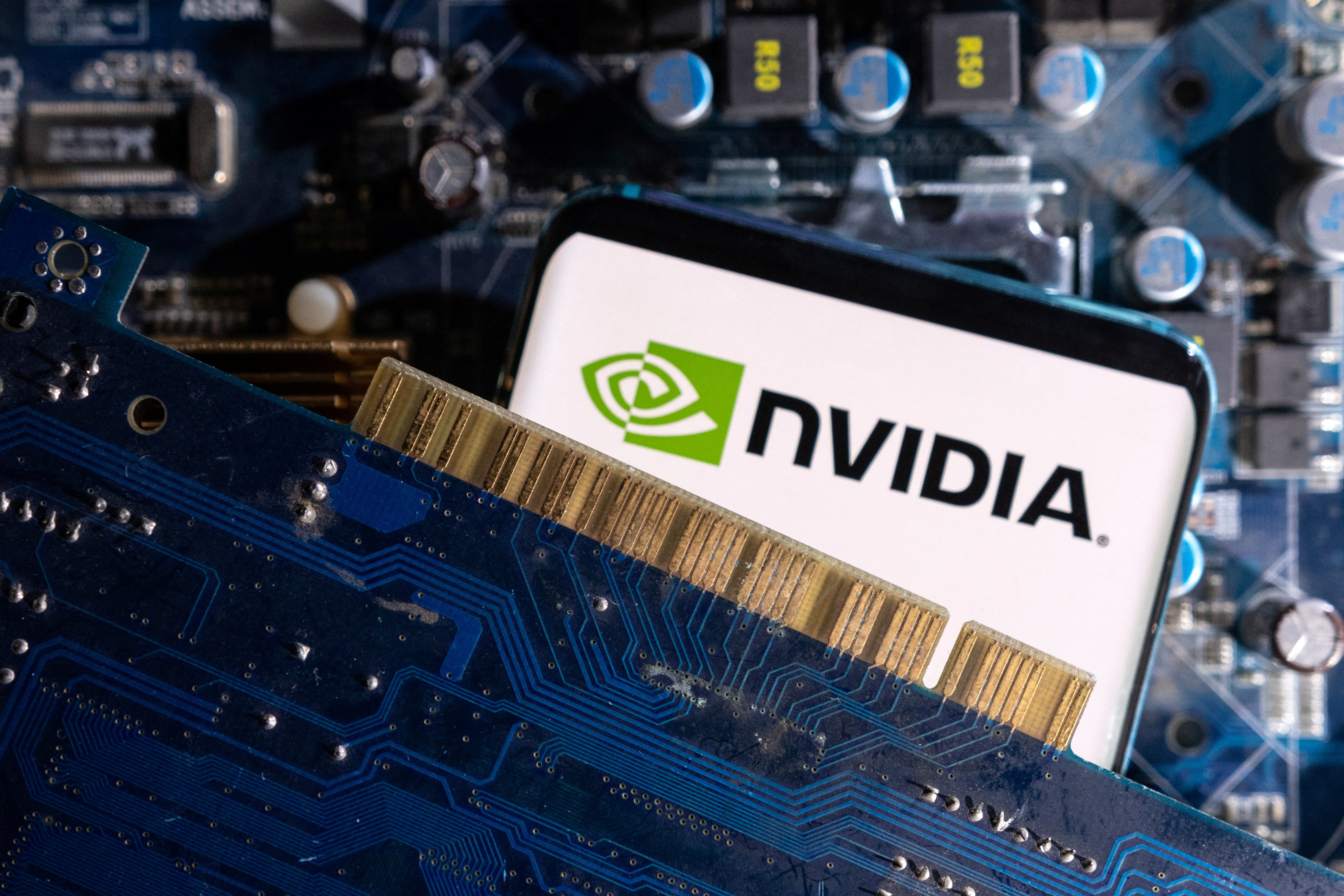 A smartphone with a displayed Nvidia logo is placed on a computer motherboard in this illustration taken on March 6, 2023. Photo: Reuters