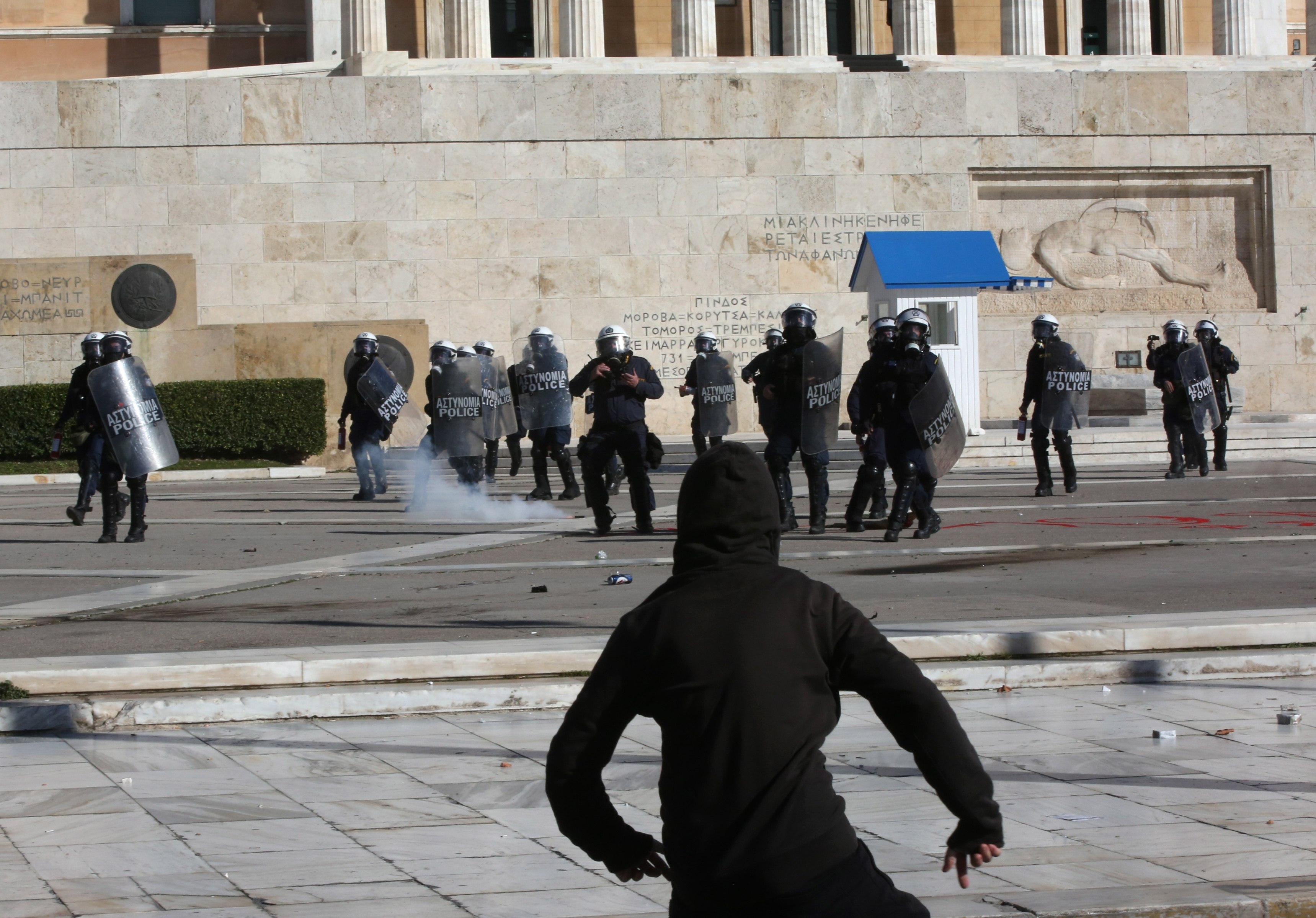 A protester throws an object towards riot police  in Athens, Greece, on Wednesday. Photo: EPA-EFE