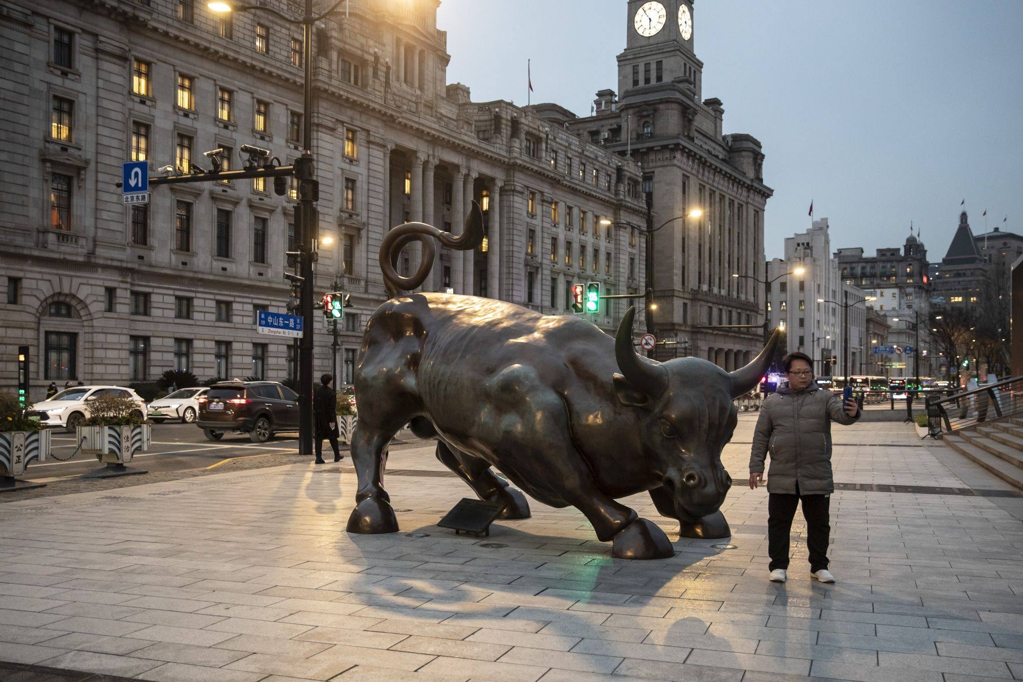 A man takes a selfie with the Bund Bull in Shanghai on February 28. Chinese stocks remain near historically low valuations and offer much promise to investors, but those hoping for a continuation of China’s reopening rally need to pay more attention to the underpinnings of the country’s growth. Photo: Bloomberg