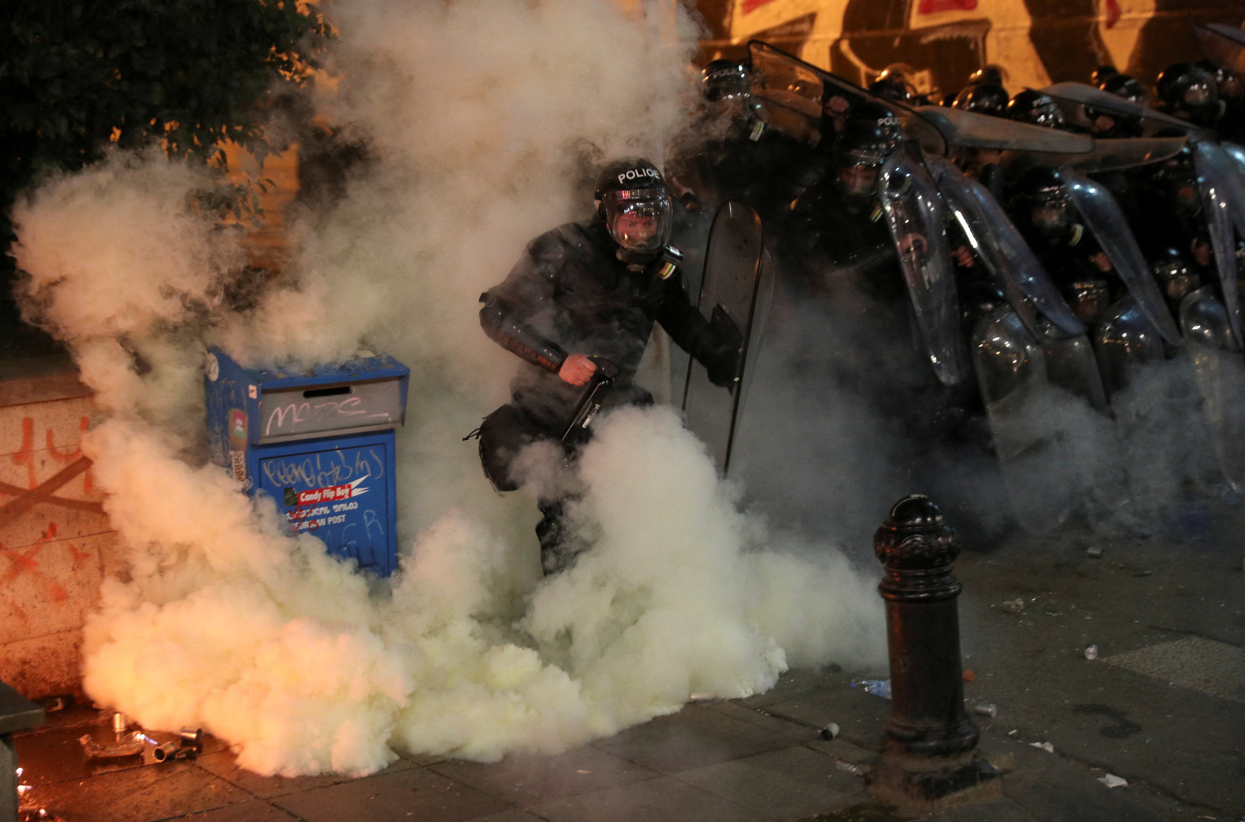 Police take cover during a protest in Tbilisi, Georgia. Photo: Reuters