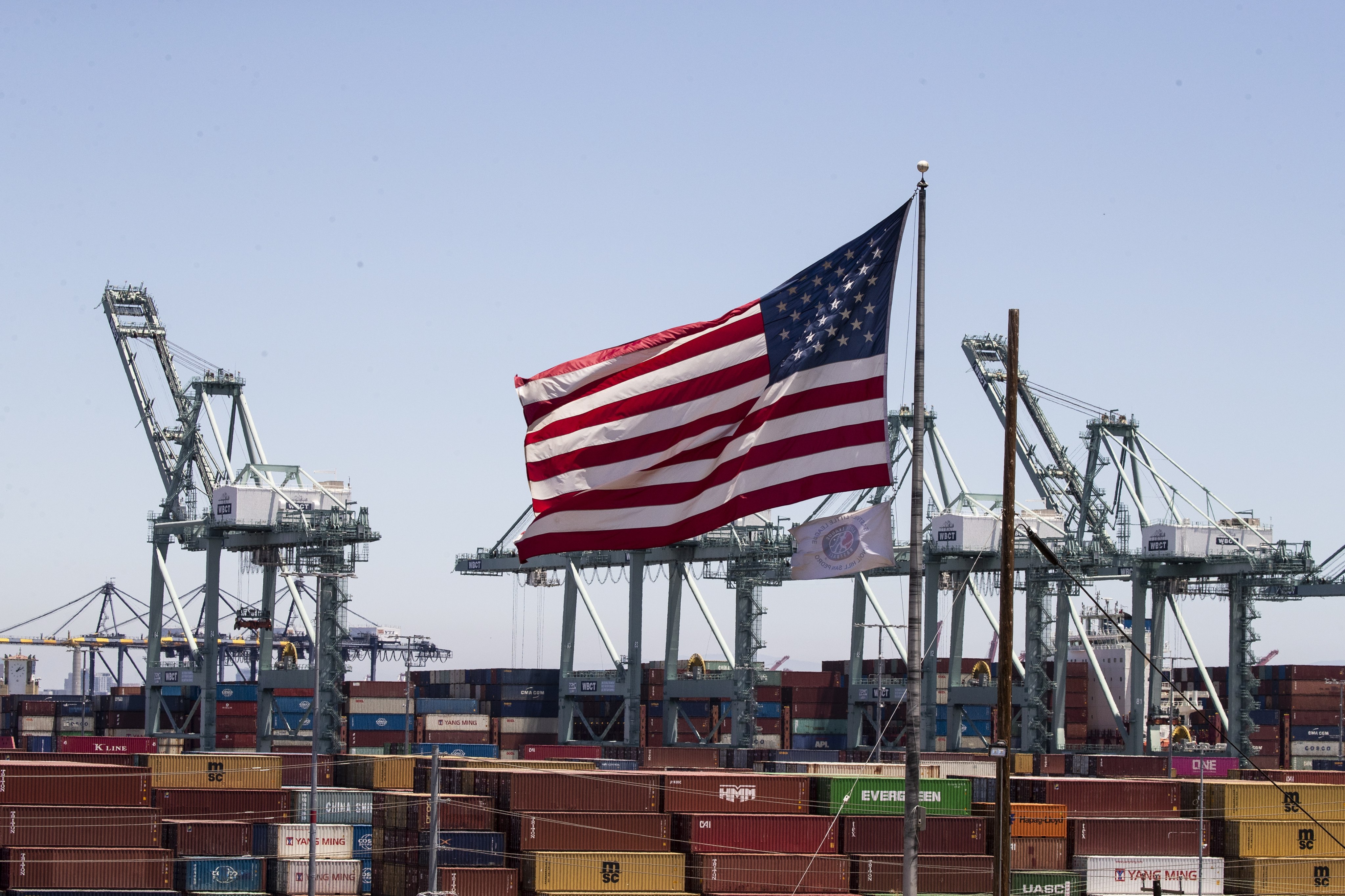 The US flag flies above containers at the Port of Los Angeles in California on July 7, 2022. The end of hyper-globalisation is creating the opportunity to right the wrongs of neoliberalism, but national security establishments in the world’s leading powers are steering the narrative towards conflict. Photo: EPA-EFE
