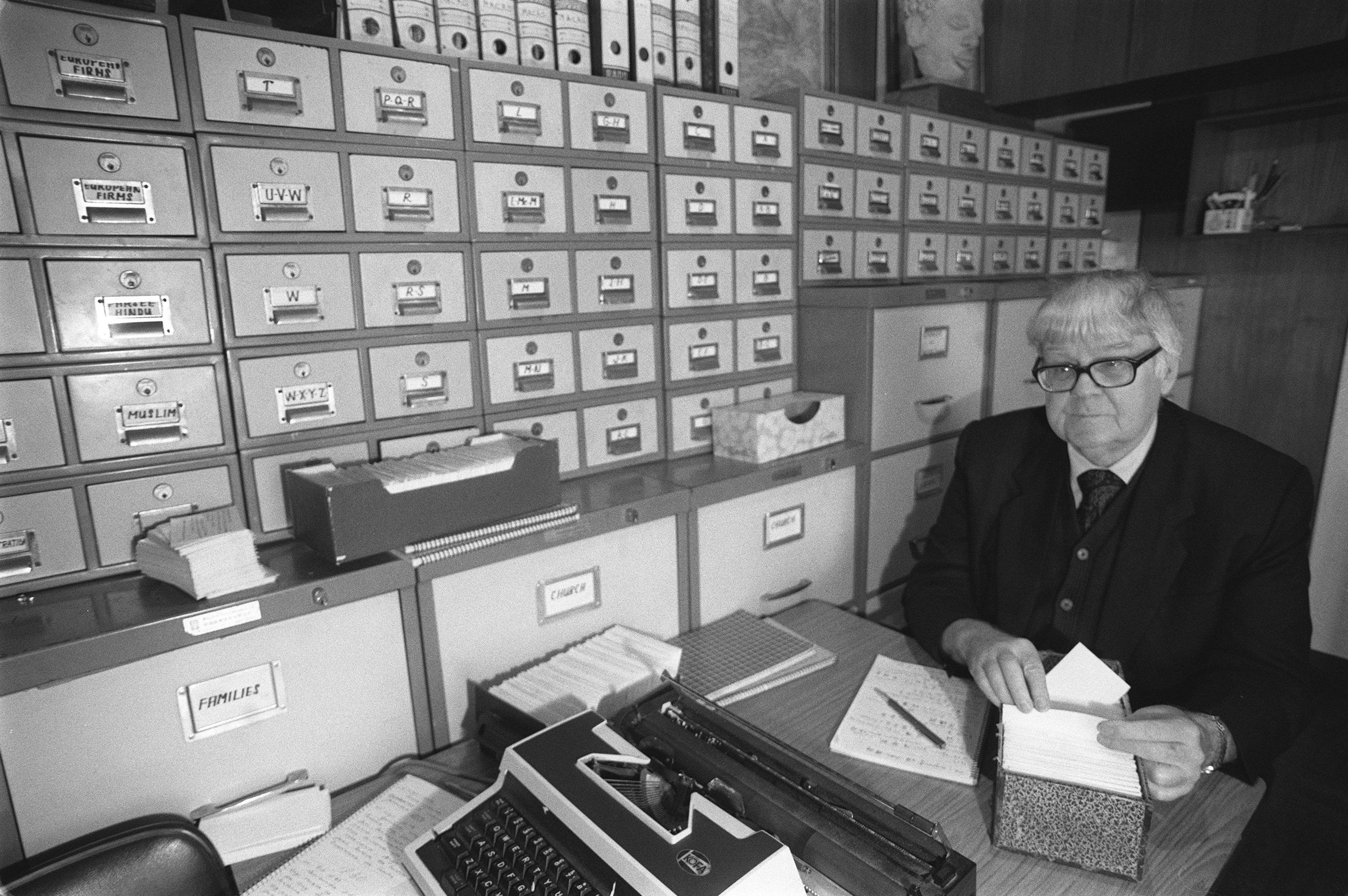 Reverend Carl Smith, Hong Kong amateur historian, sorts index cards from one of the databases that lined the walls of his apartment. Professional historians looked down on his work, but it was invaluable. Photo: SCMP
