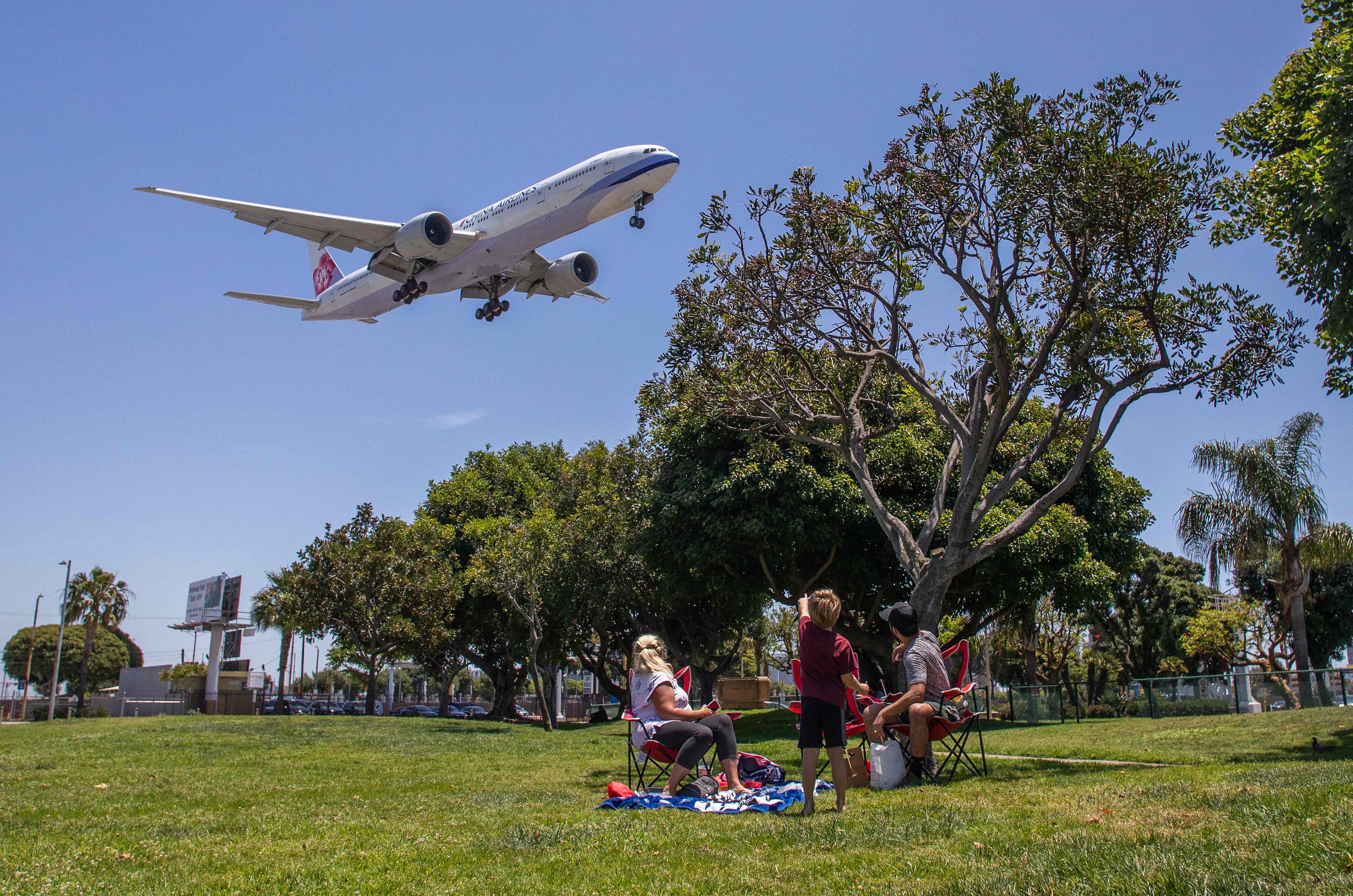 A family watches a China Airlines plane landing at Los Angeles International Airport in May 2020. Photo: AFP
