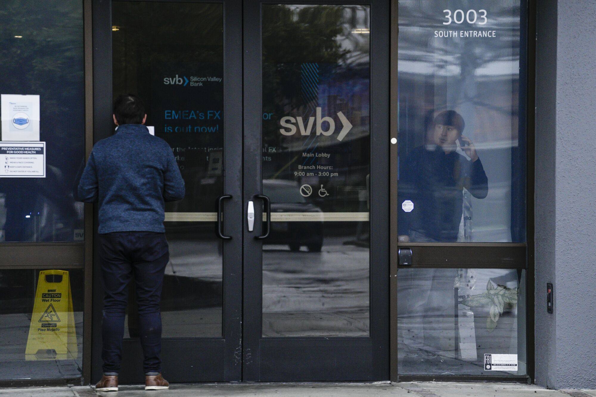 A customer reads a press release at the entrance of the Silicon Valley Bank headquarters in Santa Clara, California, on March 10, 2023. The US lender became the country’s biggest bank failure in more than a decade, after its long-established customer base of tech start-ups grew worried and yanked deposits. Photo: Bloomberg
