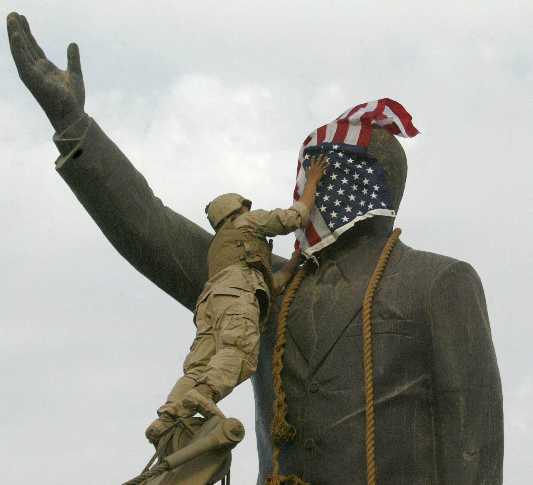 A US Marine covers the face of Saddam Hussein’s statue with the US flag in Baghdad’s al-Fardous square on April 9, 2003. File photo: AFP