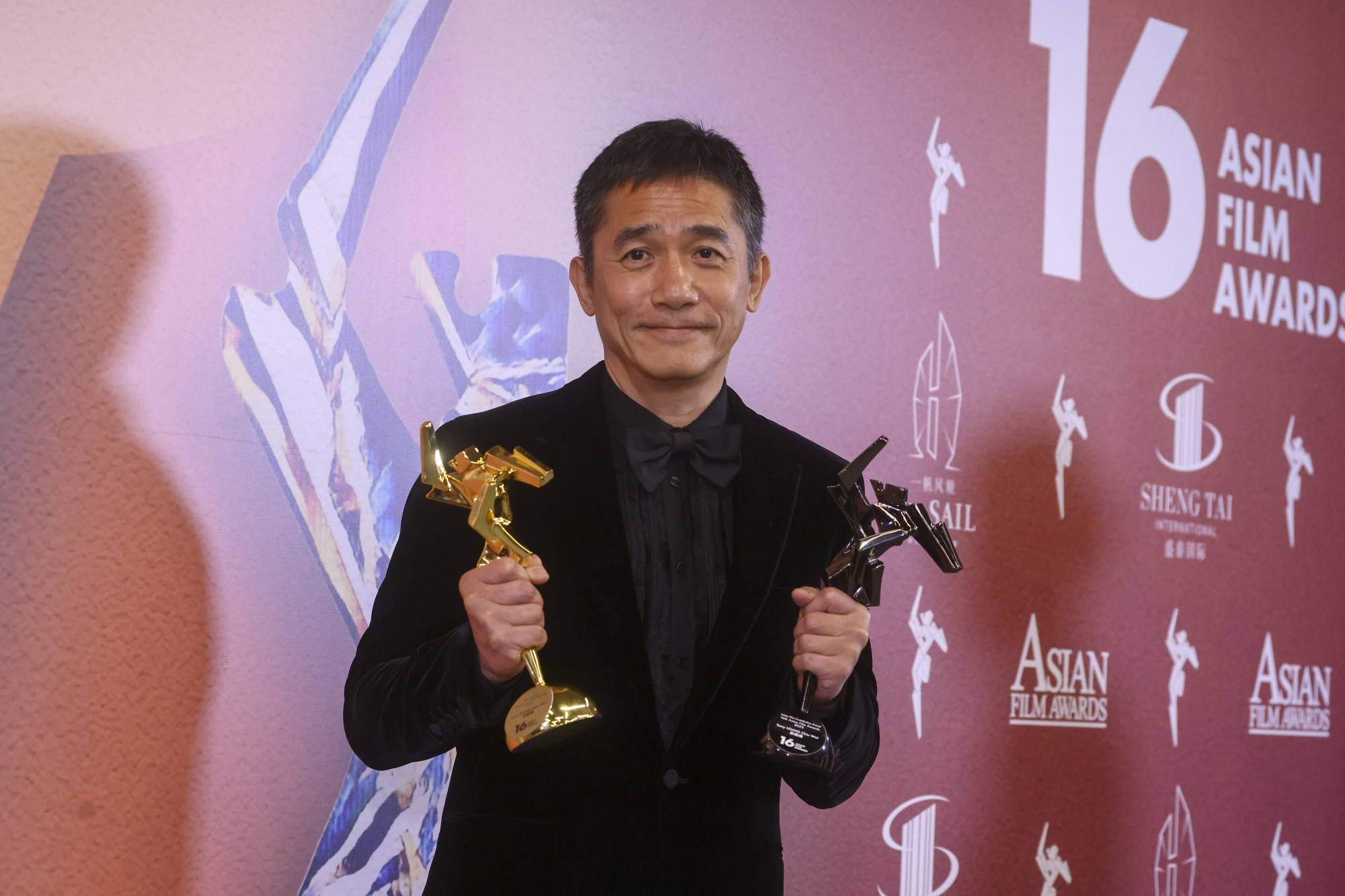 Lương Triều Vỹ chụp ảnh cùng giải nam diễn viên chính xuất sắc nhất và giải đóng góp đặc biệt cho ‘Nơi gió thổi’ tại Giải thưởng Điện ảnh Châu Á lần thứ 16 được tổ chức tại Hồng Kông vào ngày 12 tháng 3. Ảnh: Dickson Lee