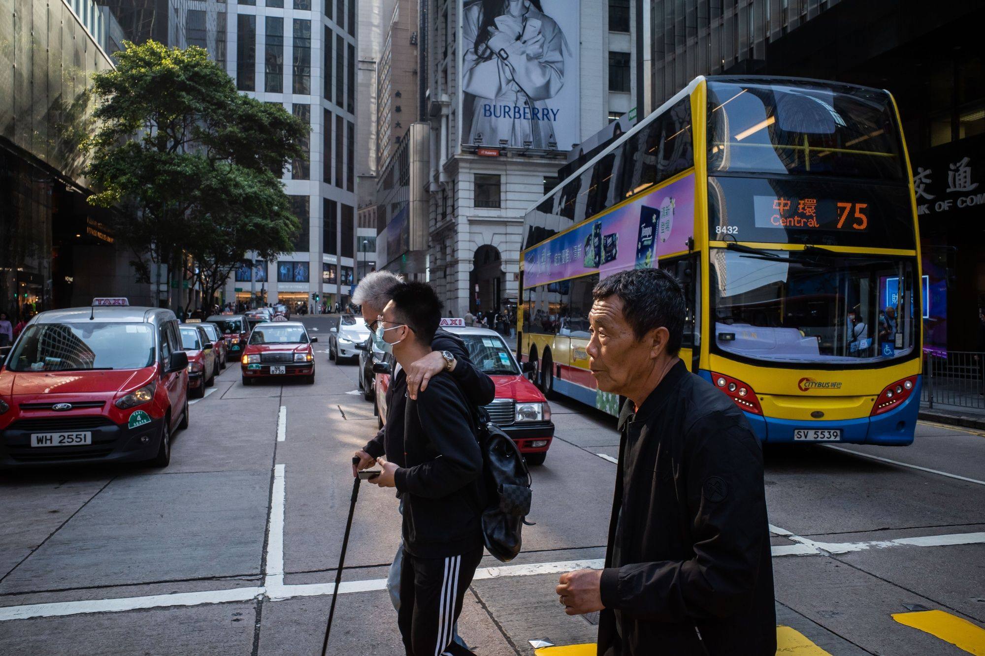 Pedestrians cross a road in Hong Kong on March 1, 2023 after the end of one of the world’s longest mask mandates. Photo: Bloomberg