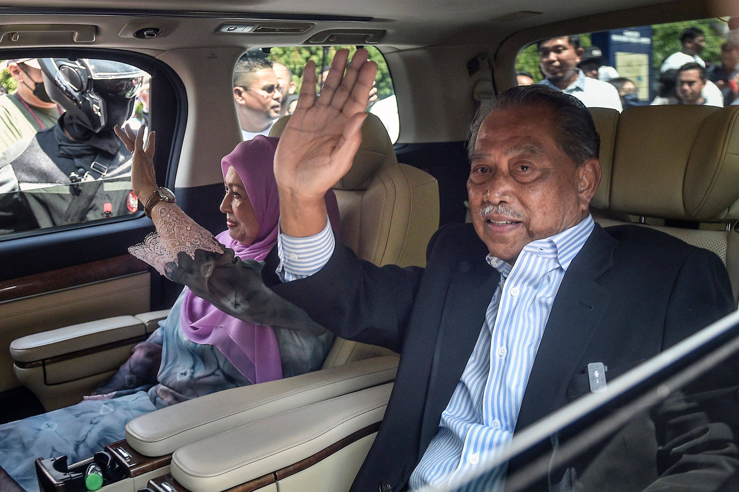 Former prime minister of Malaysia and Perikatan Nasional chairman Muhyiddin Yassin (right) waves as he leaves the Kuala Lumpur High Court after being charged with corruption in Kuala Lumpur on March 10. Photo: AFP