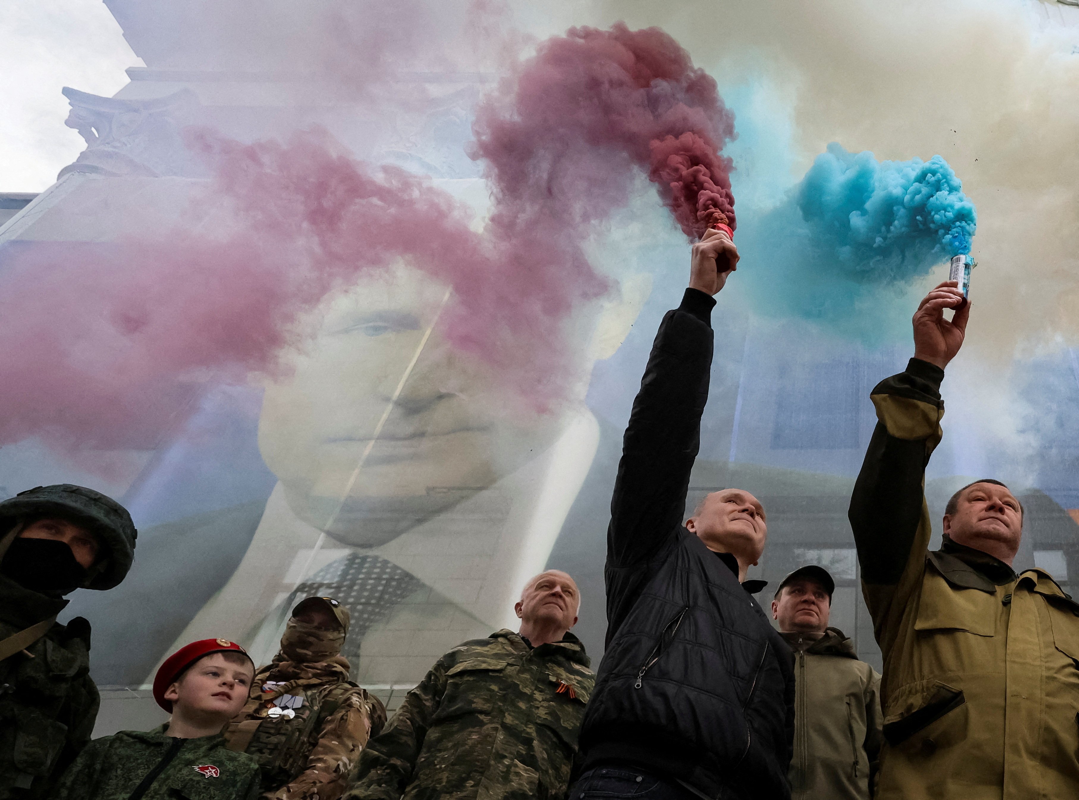 Participants burn flares in front of a banner with a portrait of Russian President Vladimir Putin during a patriotic flash mob marking the ninth anniversary of Russia’s annexation of Crimea. Photo: Reuters