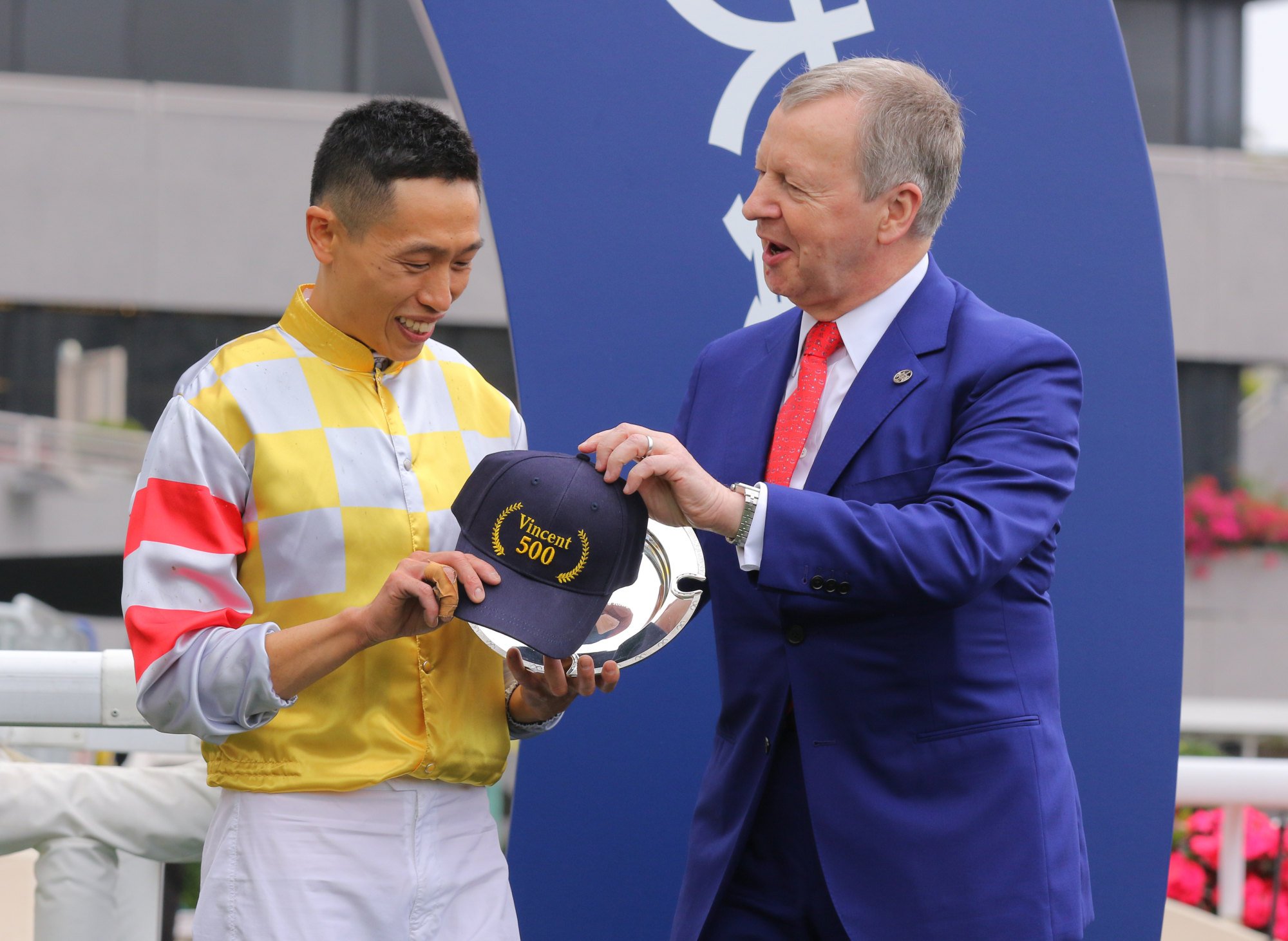 Jockey Vincent Ho receives a commemorative cap from Jockey Club chief executive Winfried Engelbrecht-Bresges.