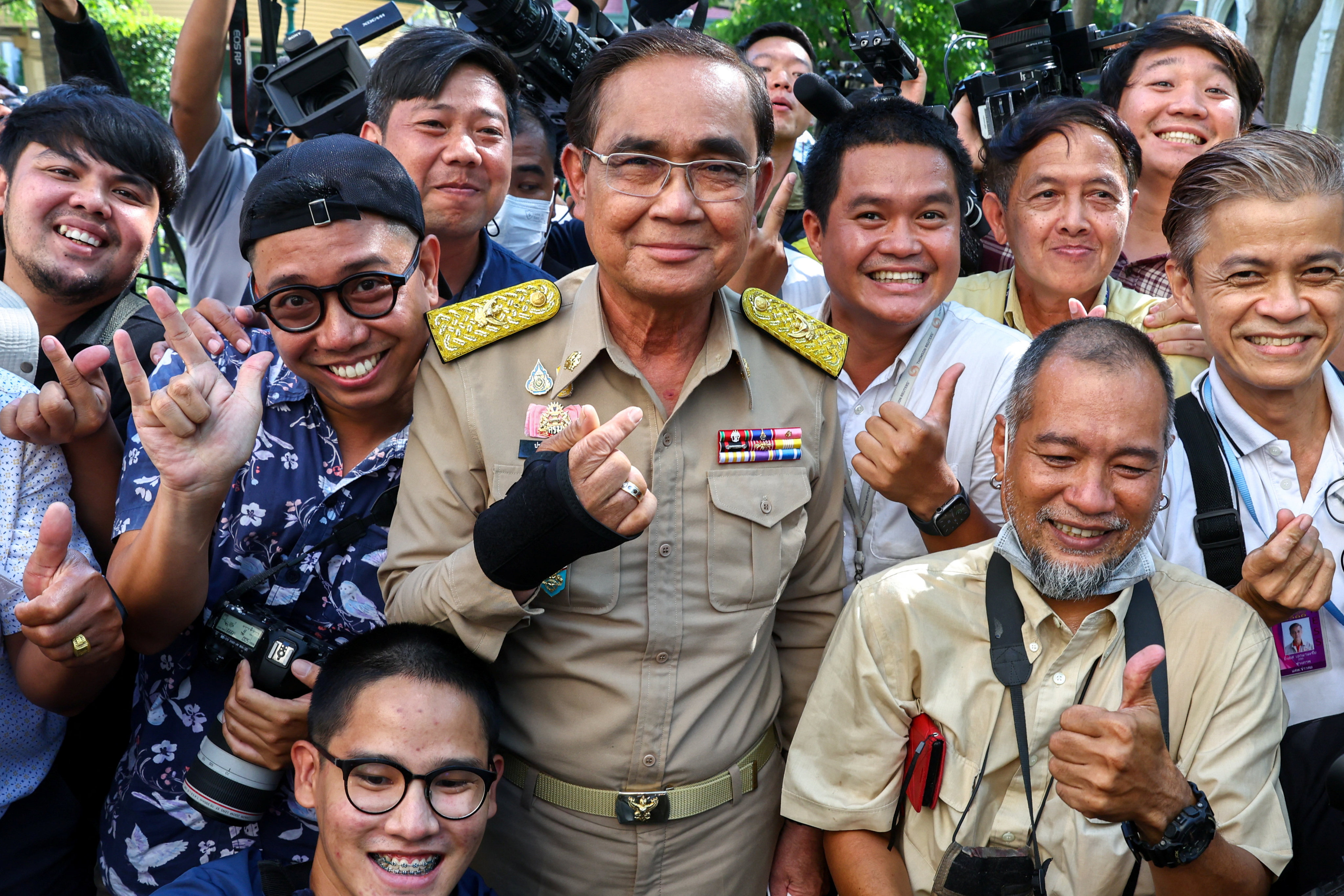 Thailand’s Prime Minister Prayuth Chan-ocha poses with members of the media after the king endorsed a decree to dissolve parliament. Photo: Reuters