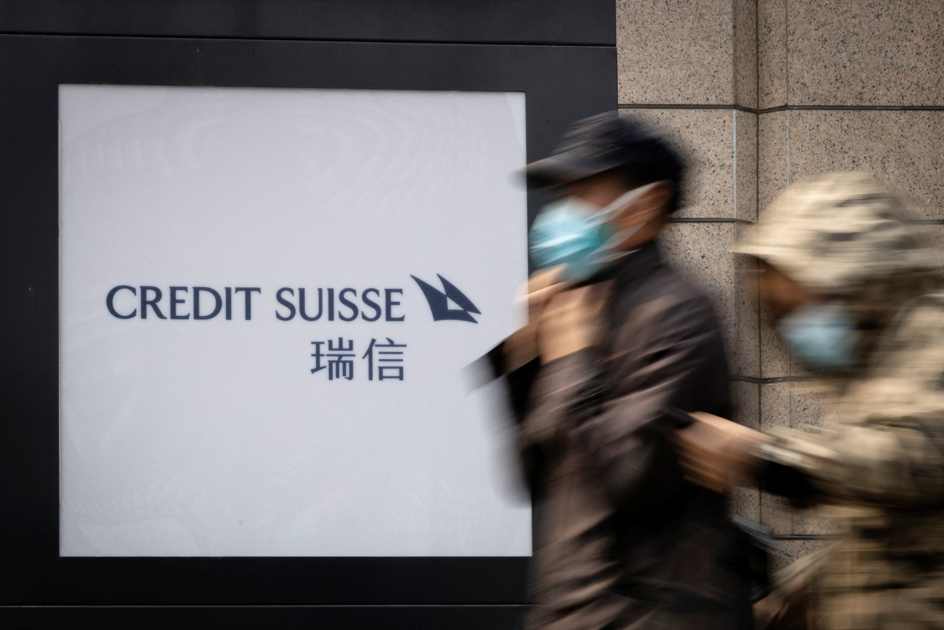 People walk past the Credit Suisse logo outside the Swiss bank’s representative office in Beijing. Photo: Reuters