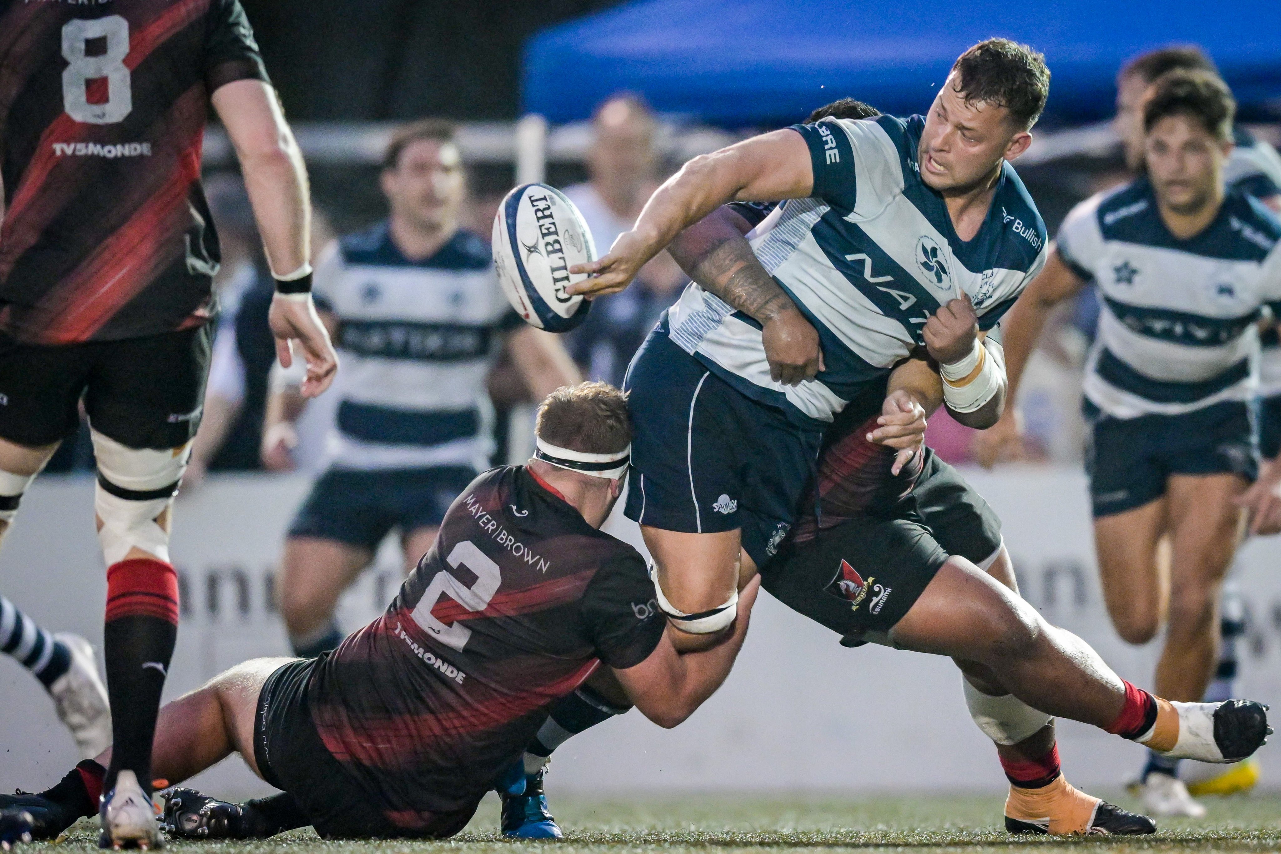 Hong Kong Football Club captain Josh Hrstich (right) offloads the ball while being tackled by Valley’s Luke Dewar during the grand final of the 2022-23 Nan Fung Group/Sewit Men’s Premiership. Photo: Ike Li / Ike Images