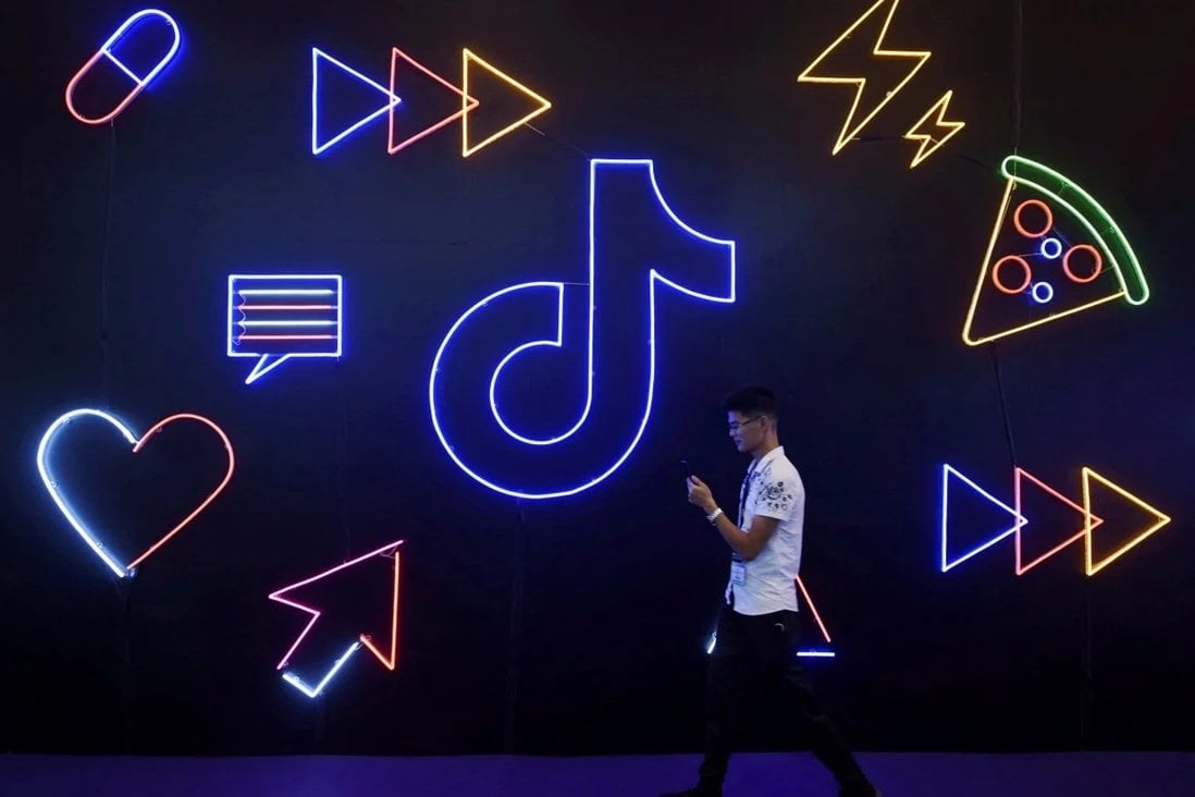 A man holding a phone walks past a sign of Chinese company ByteDance’s app TikTok, known locally as Douyin. Photo: Reuters