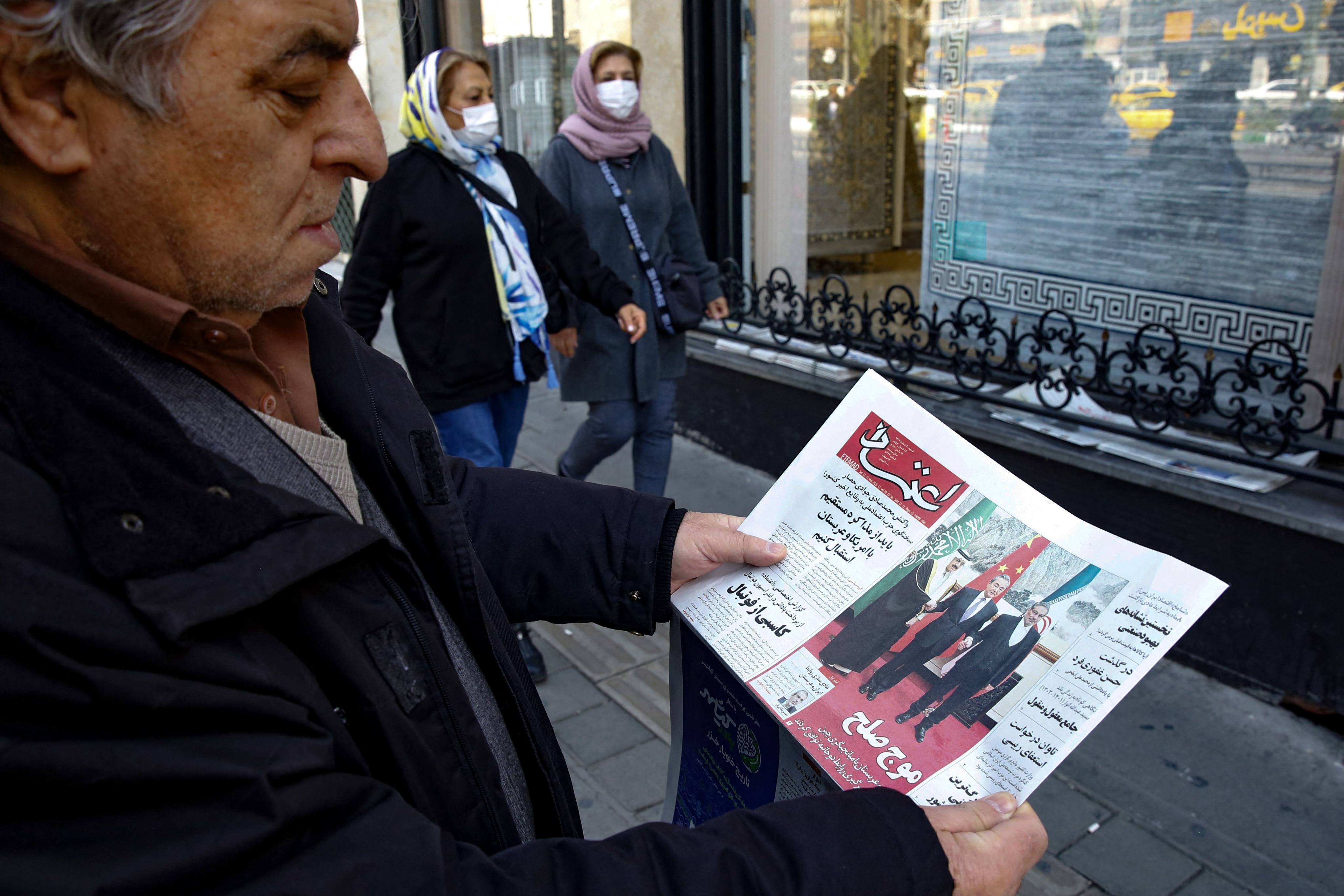 A man in Tehran reads a local newspaper reporting on March 11 the China-brokered deal between Iran and Saudi Arabia to restore ties, signed in Beijing the previous day. Photo: AFP